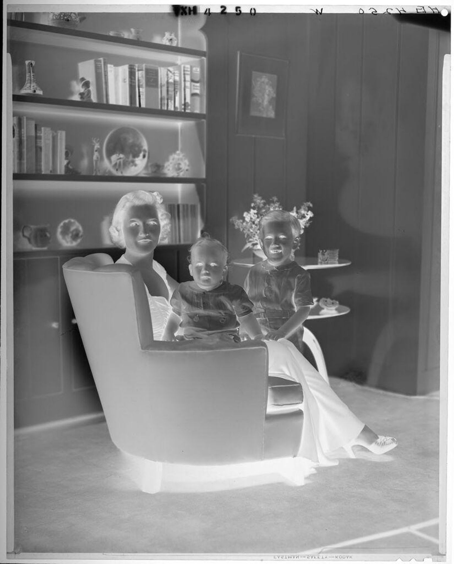 Untitled (woman in long formal dress seated with two children in living room armchair) by Paul Gittings