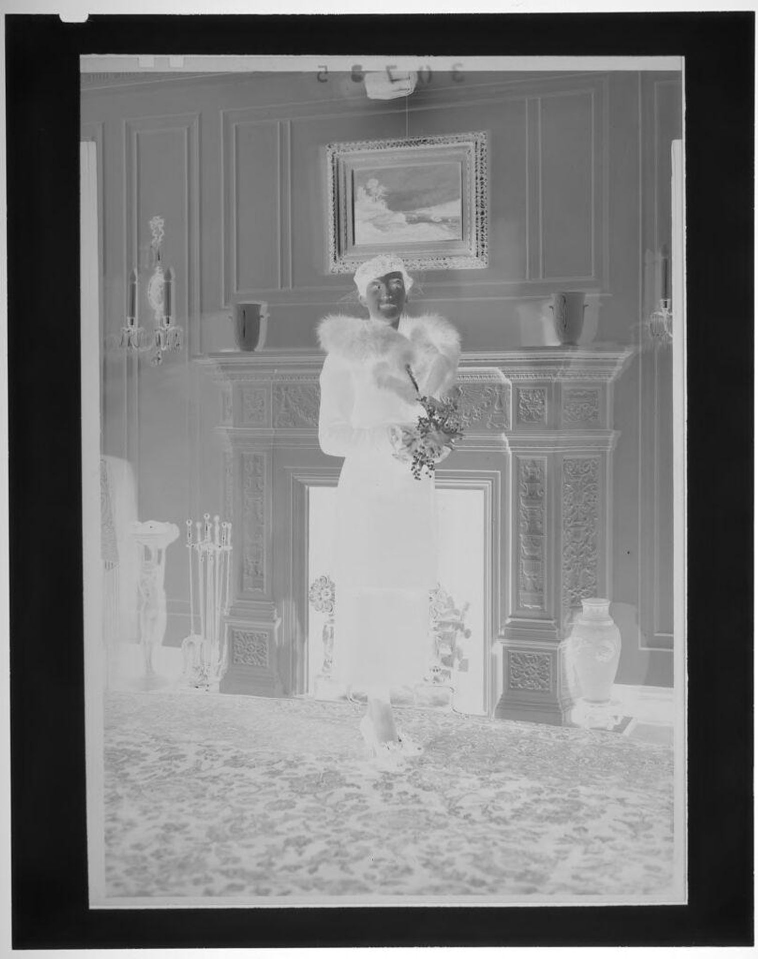 Untitled (woman posed in front of fireplace wearing heels and black coat with fur collar) by Martin Schweig