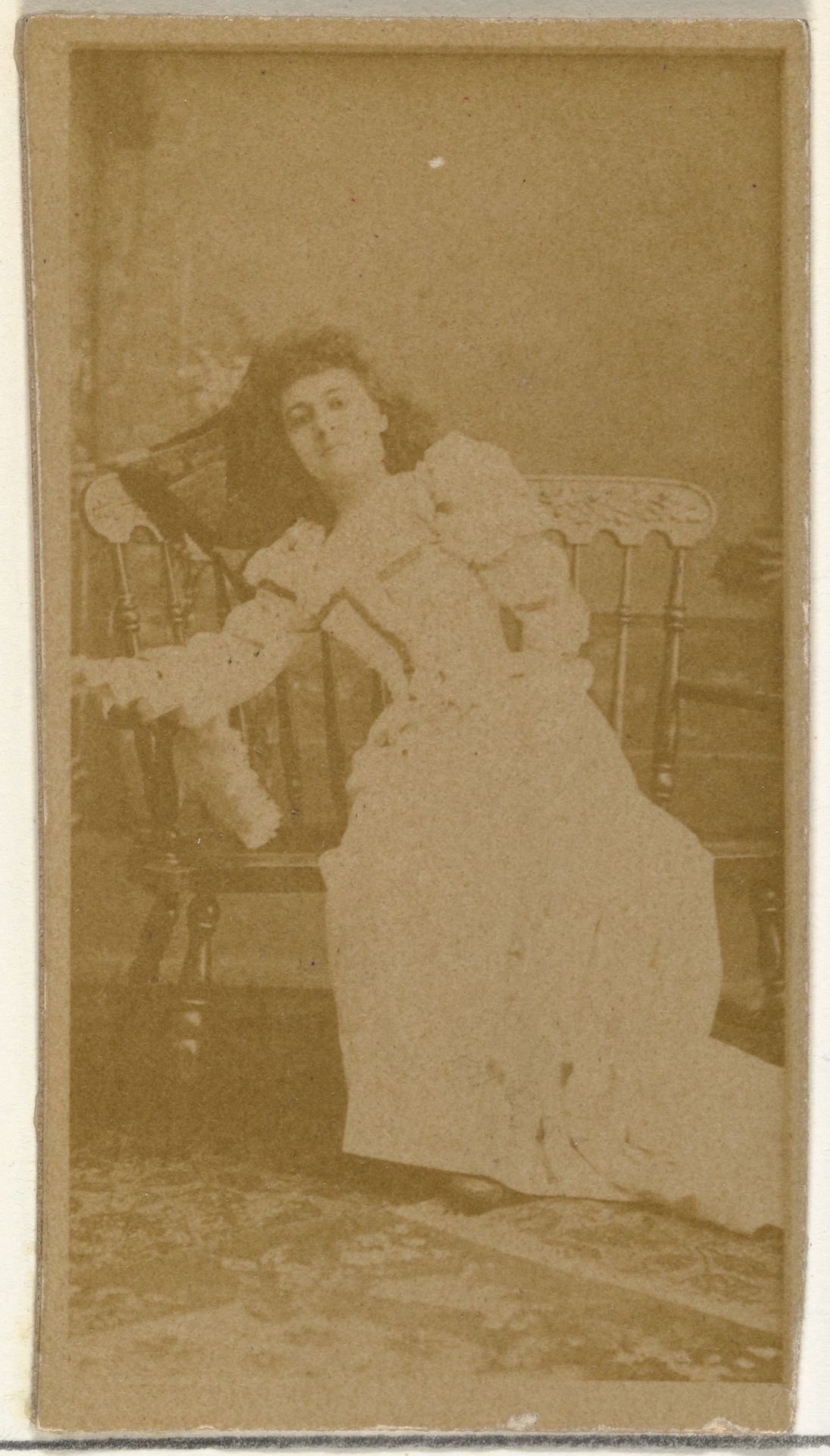 [Actress reclining on wooden seat], from the Actors and Actresses series (N145-8) issued by Duke Sons & Co. to promote Duke Cigarettes by W. Duke, Sons & Co.