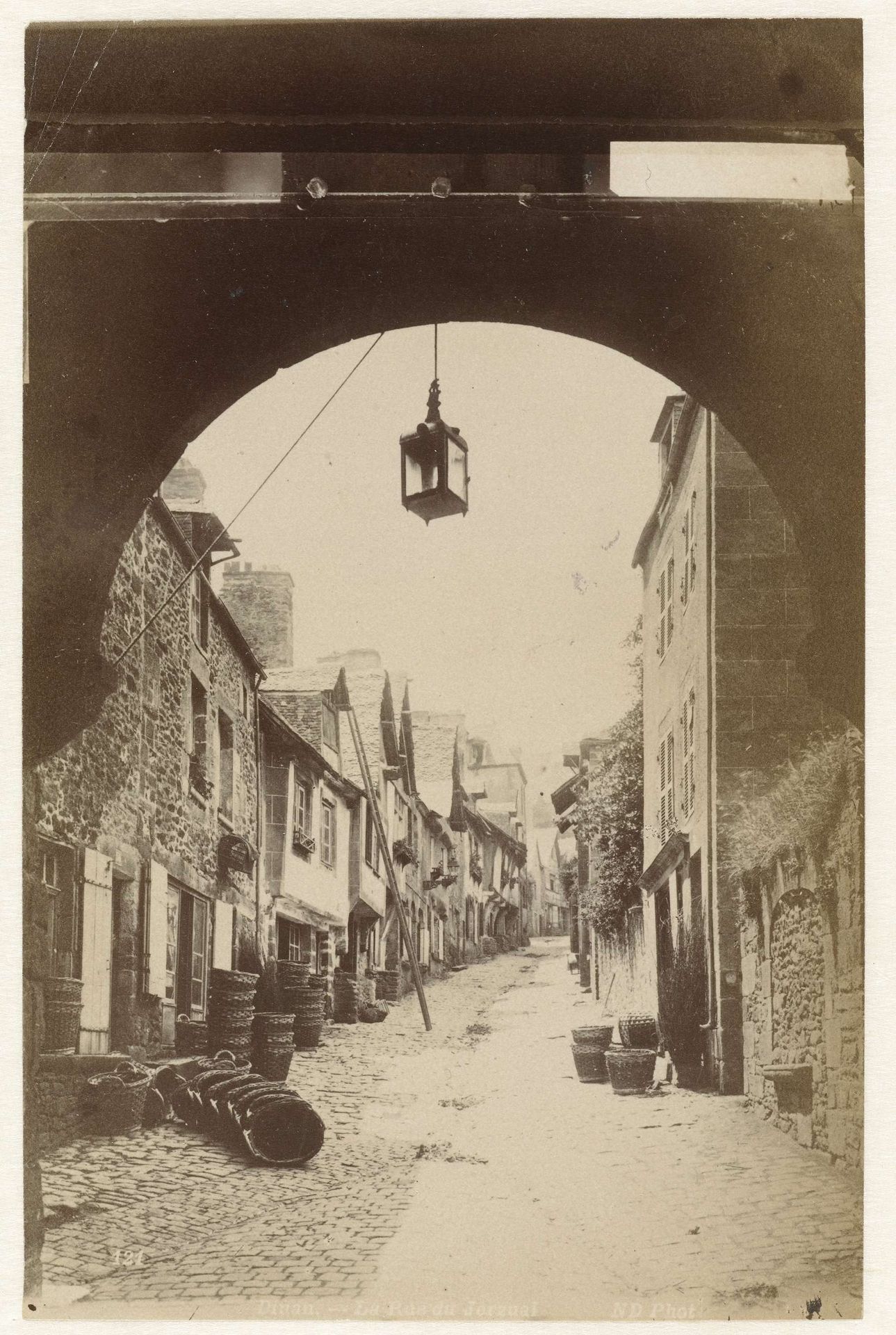 Straatgezicht in Dinan, gezien door een poort by Étienne Neurdein