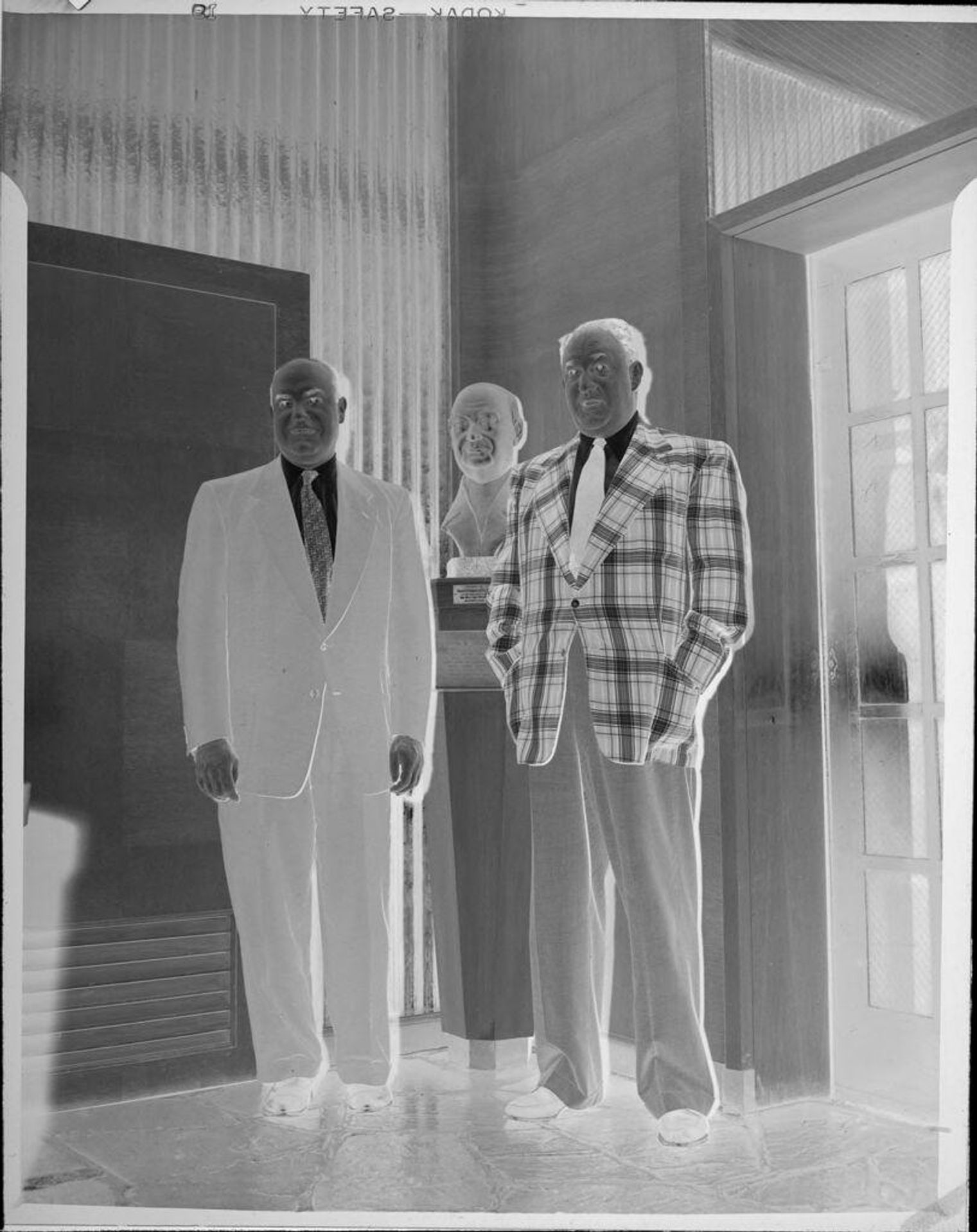 Untitled (two men standing next to bust) by Peter James Studio