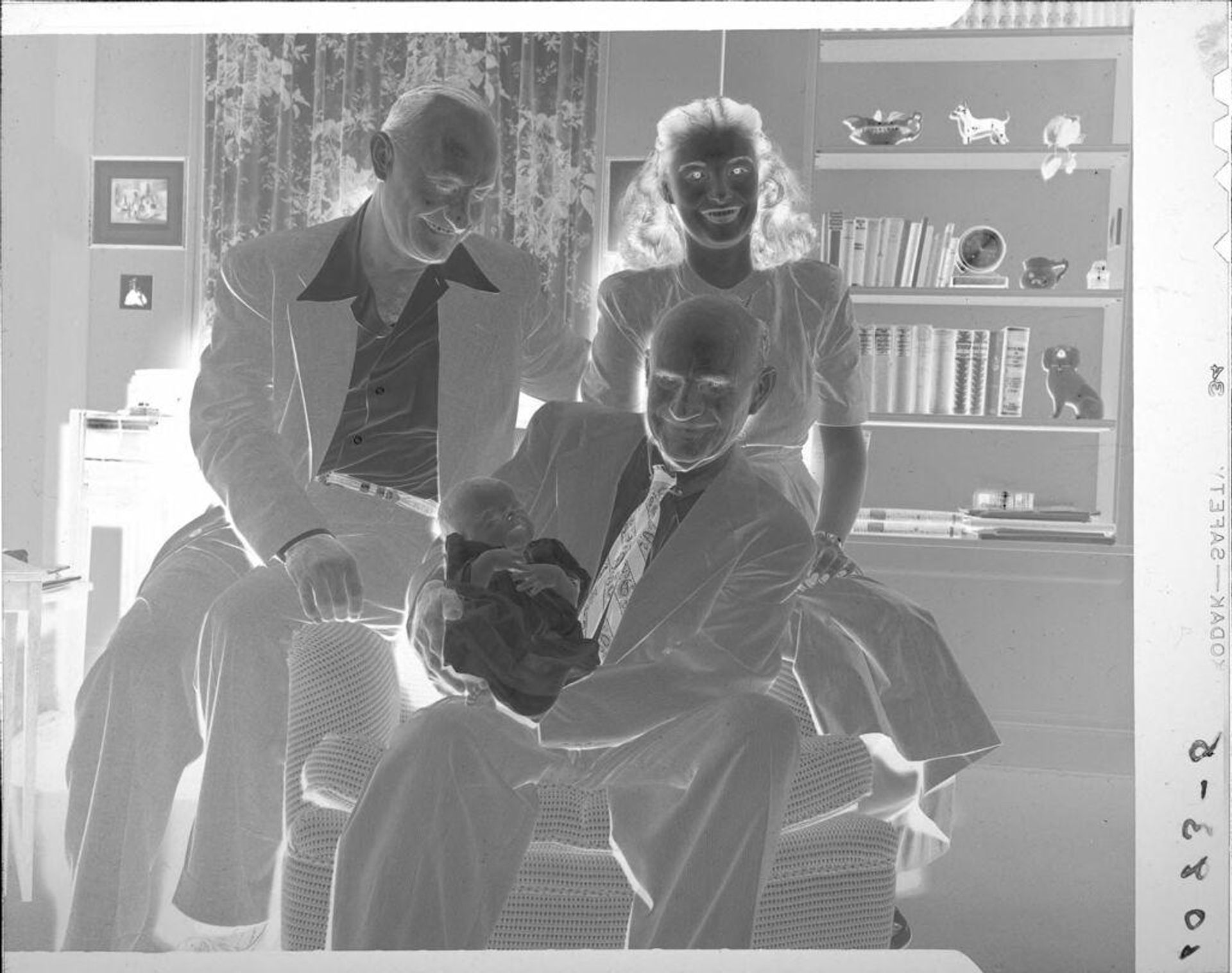 Untitled (woman and men holding baby) by John Howell