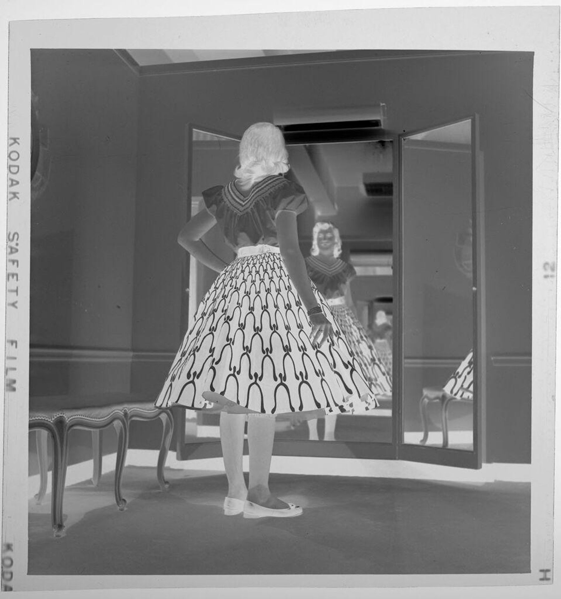 Untitled (woman in large hooped skirt looking in full-length mirror) by Jack Gould