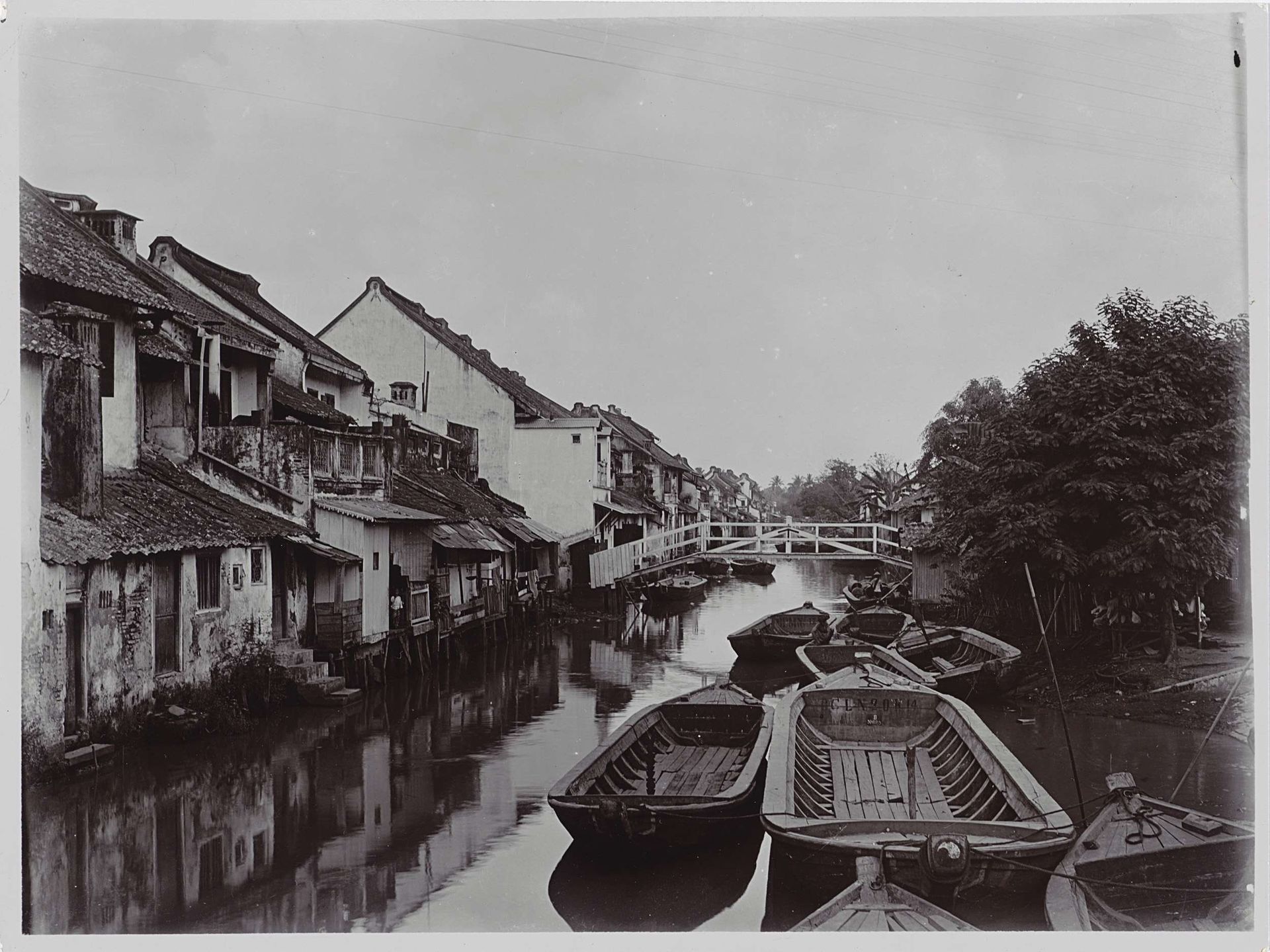 Zicht langs een water op Java met aan weerszijden woningen. by Johanna Hermina Marmelstein