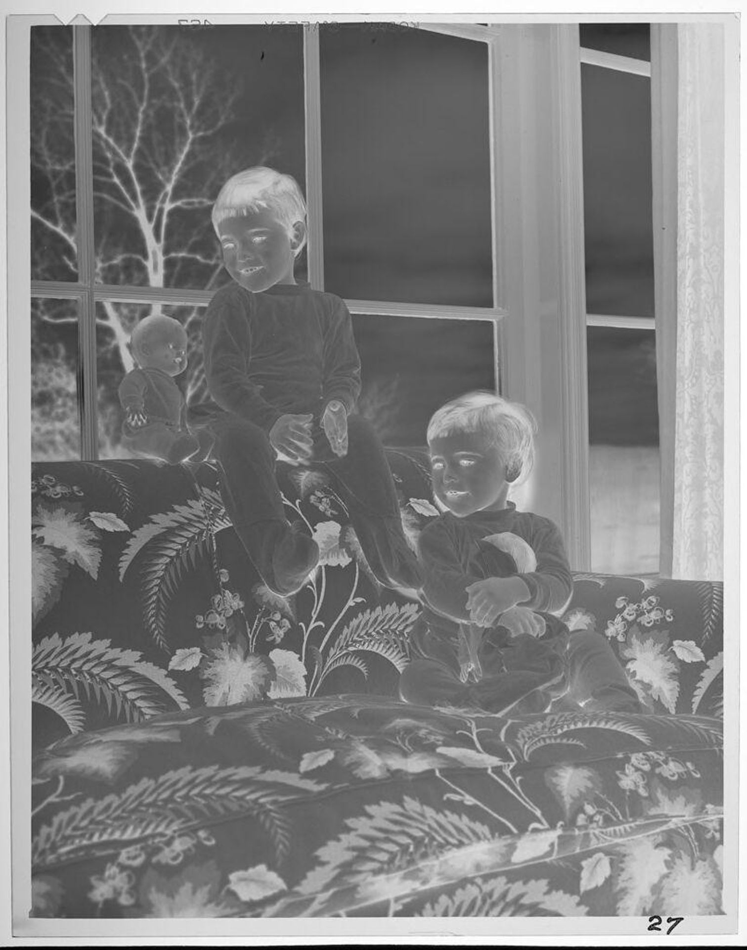 Untitled (two children with dolls on floral-printed couch) by Lucian and Mary Brown