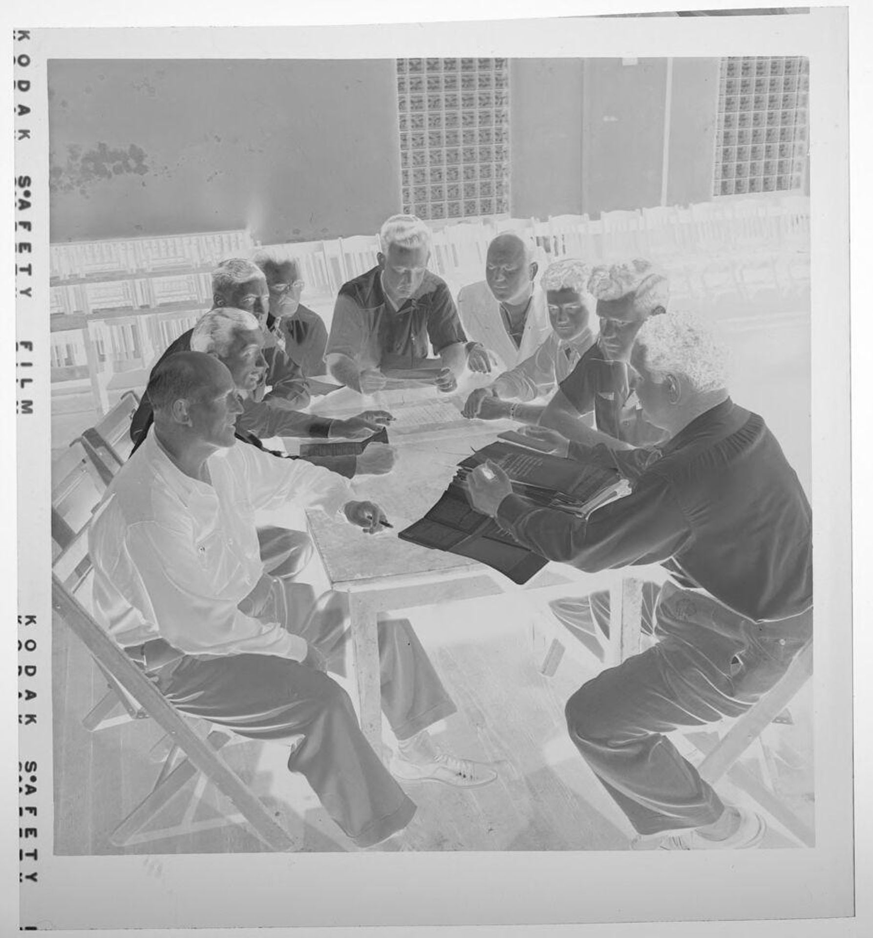 Untitled (men sitting around table looking at papers) by Jack Gould