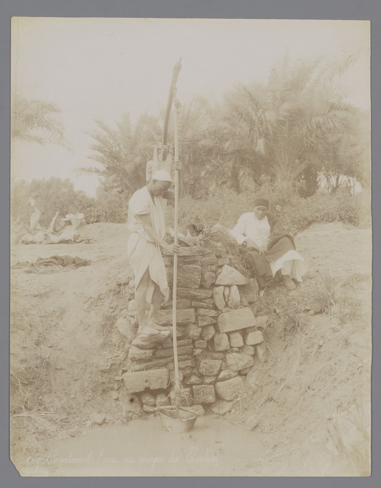 Twee onbekende mannen bij een waterpomp by Félix Bonfils
