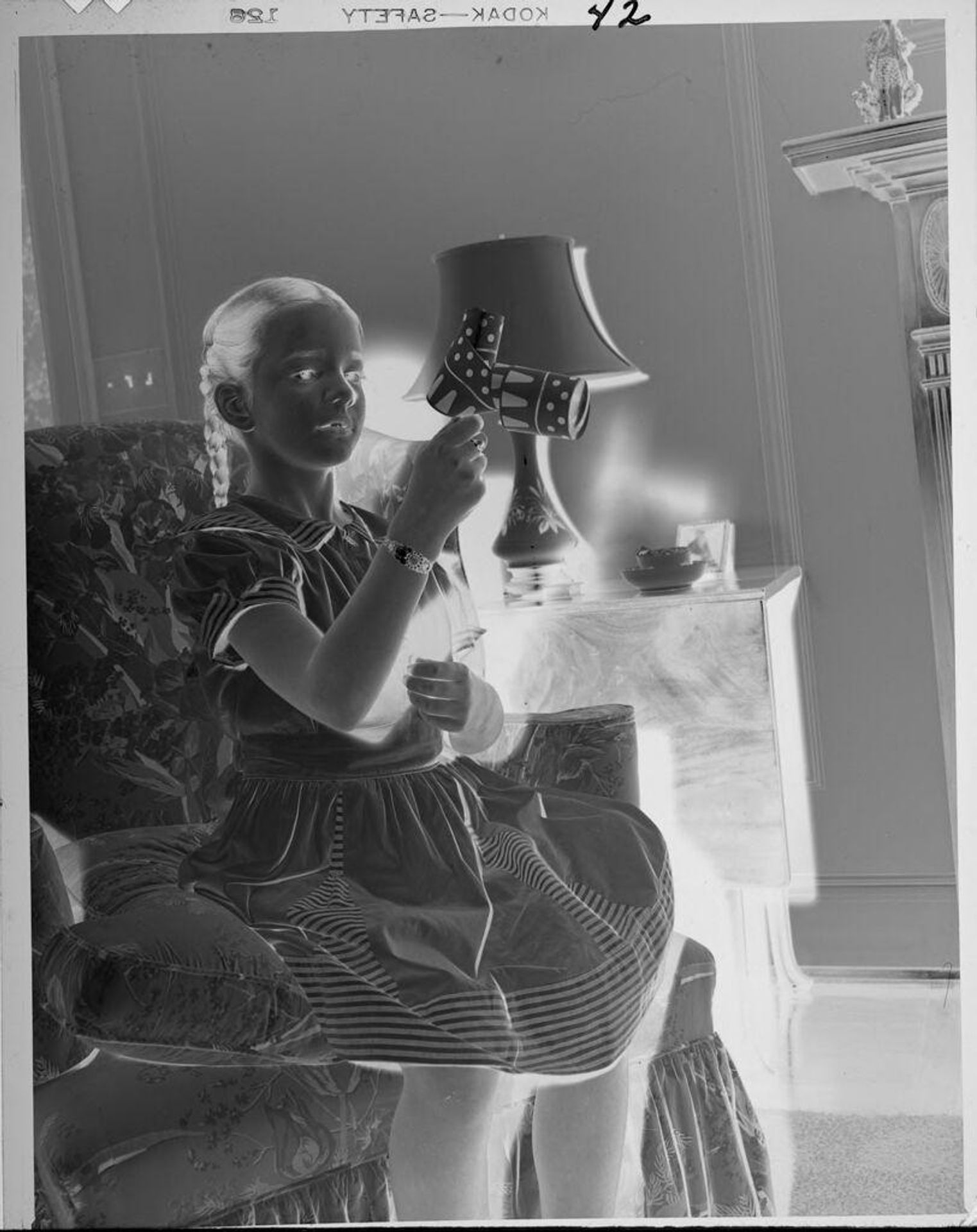Untitled (girl playing with party streamer) by Lucian and Mary Brown