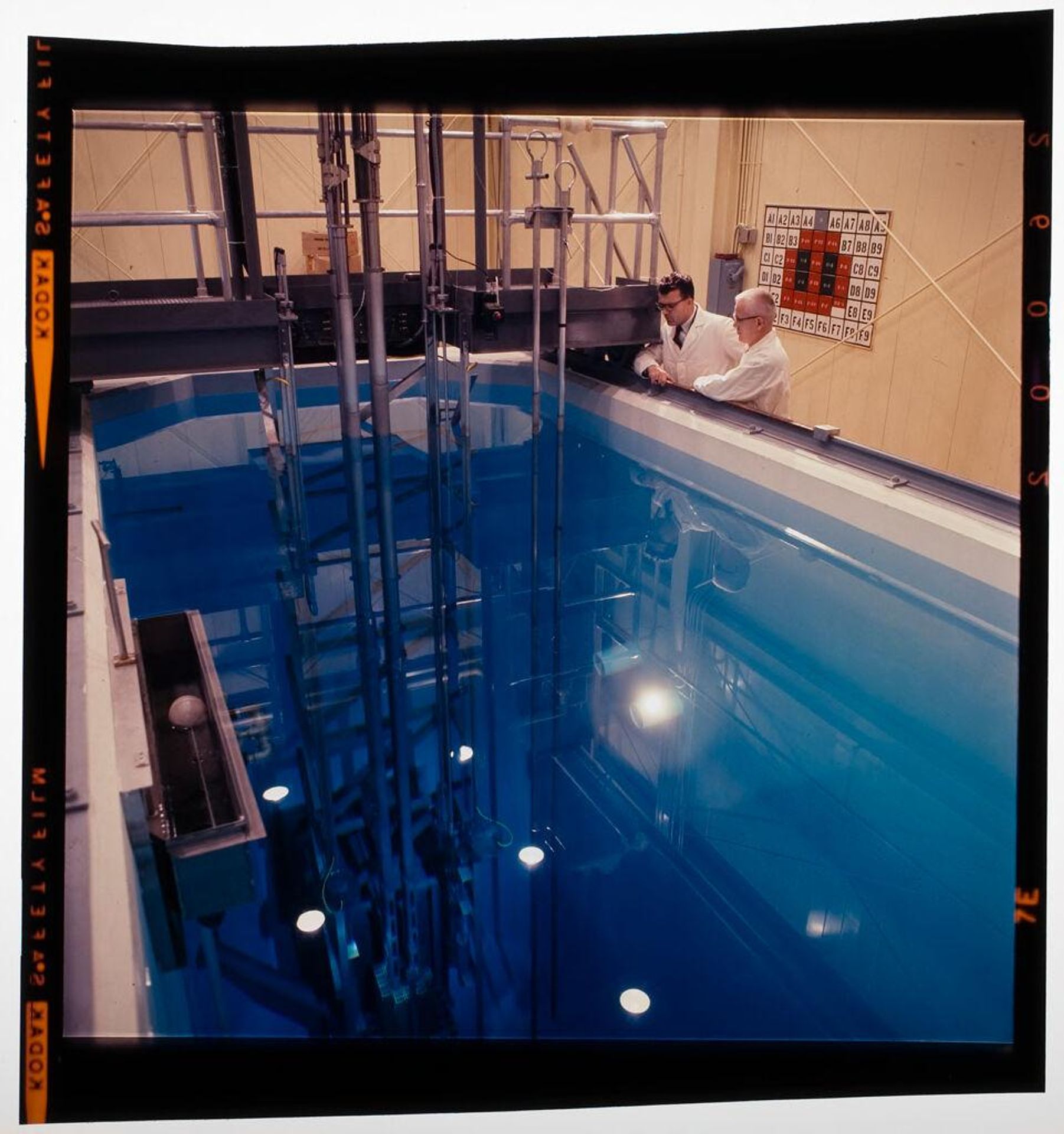 Untitled (scientists looking into pool of water at research facility) by Jack Gould