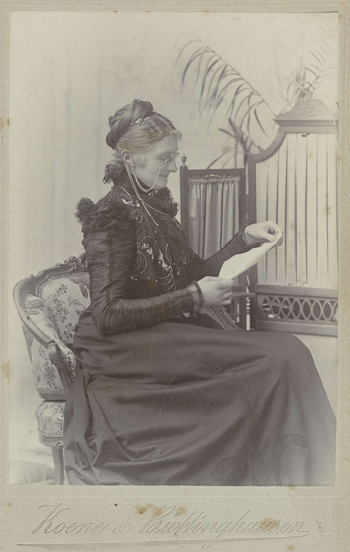 Portret van Eva Fockeline Boelen lezend in een stoel by Koene & Büttinghausen
