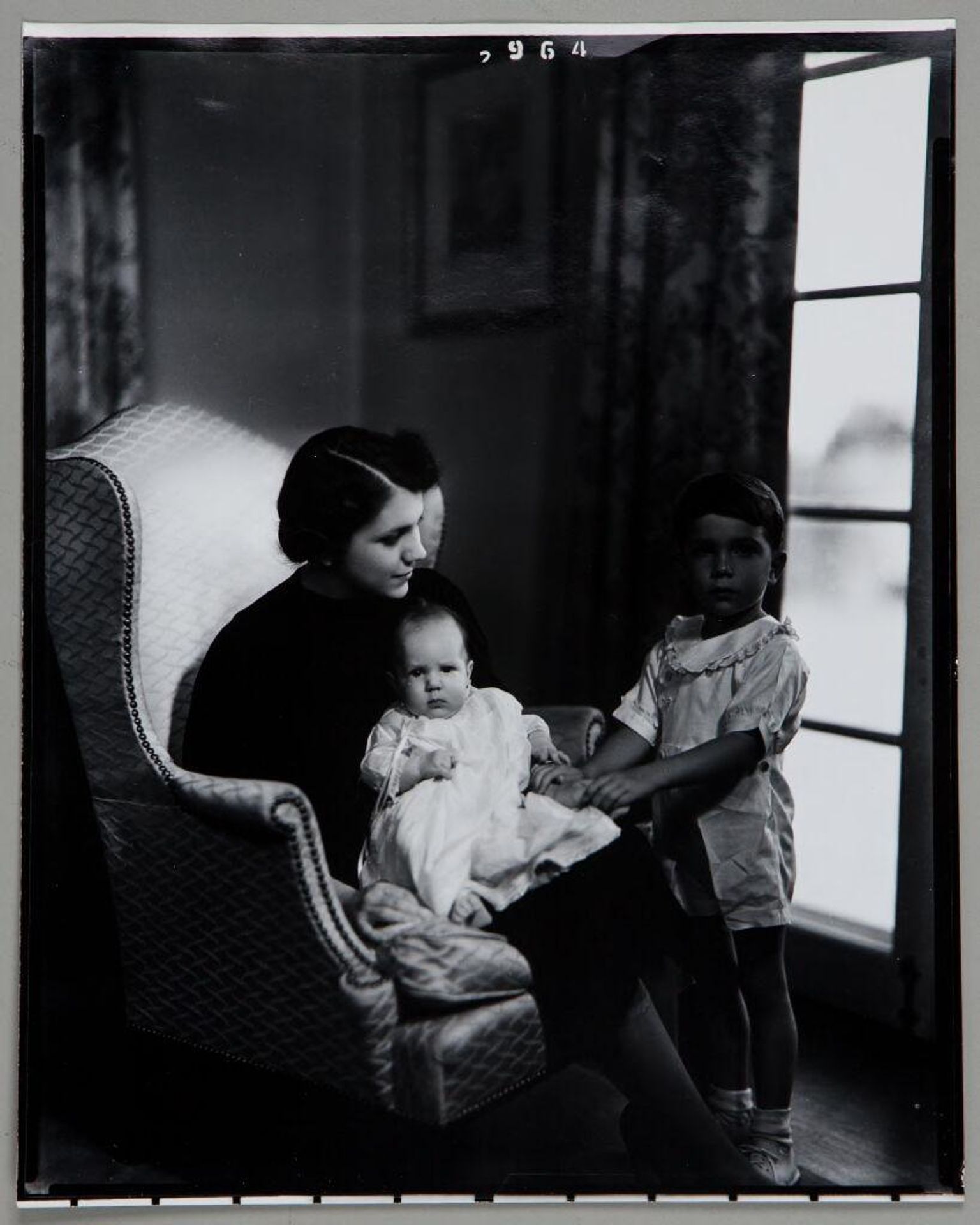 Untitled (woman seated in chair with baby on lap, little boy standing at side) by Paul Gittings