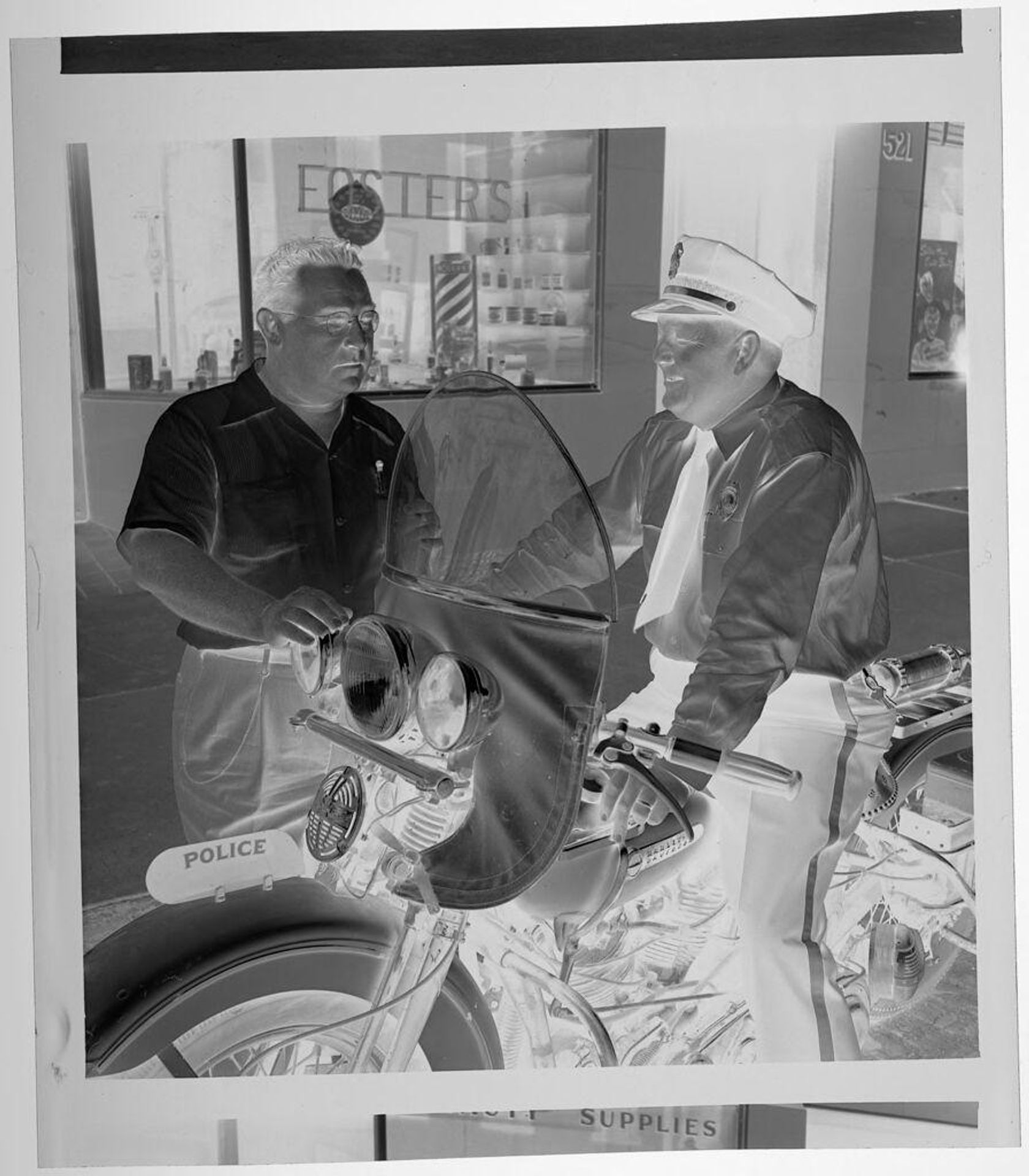 Untitled (policeman on motorcycle talking to another man) by Jack Gould