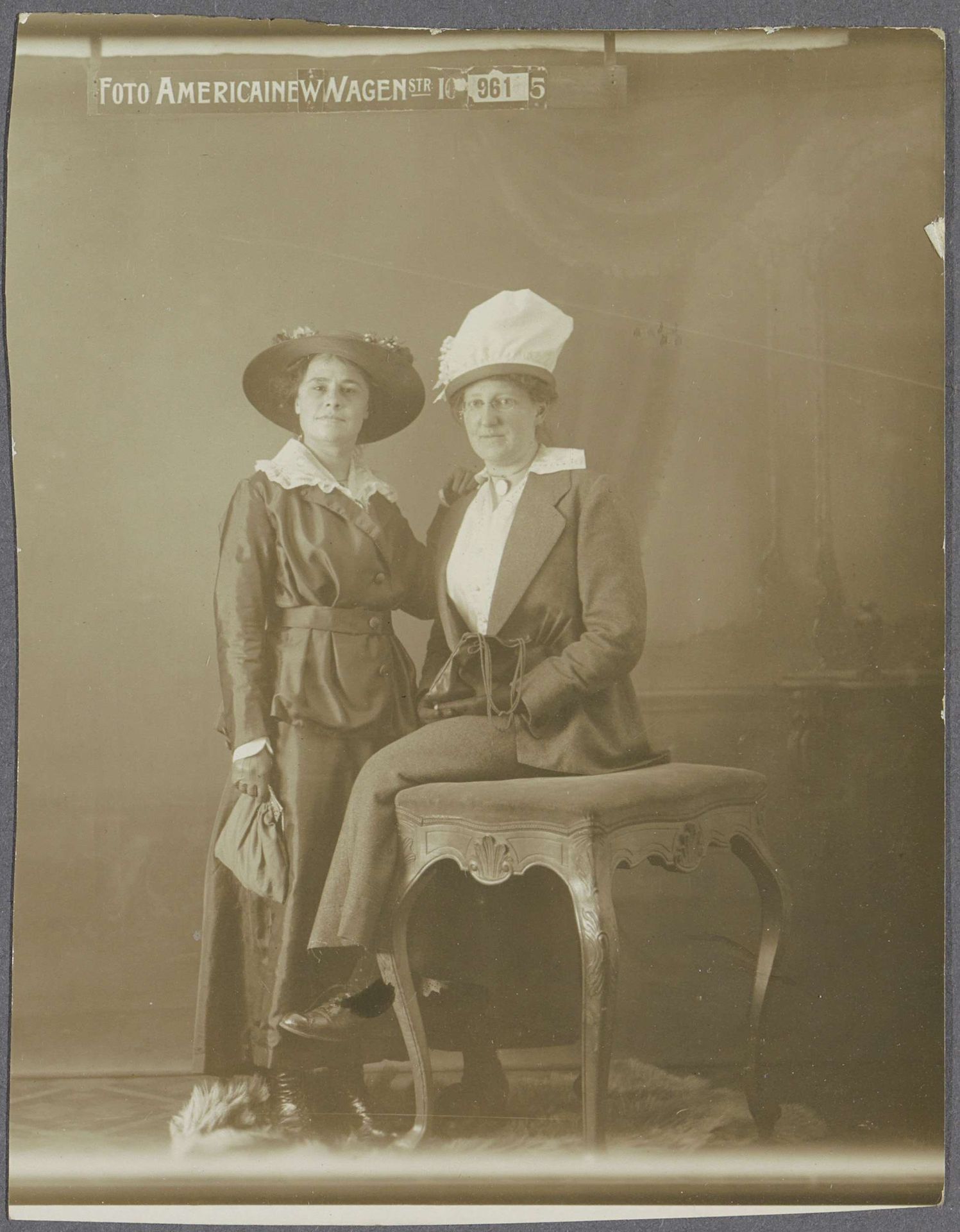 Portret van twee vrouwen met hoeden, de een staand, de ander zittend by Foto Americaine