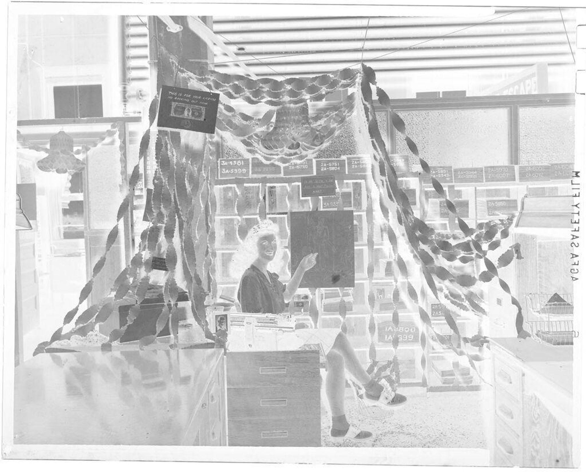 Untitled (woman seated at decorated desk) by John Deusing