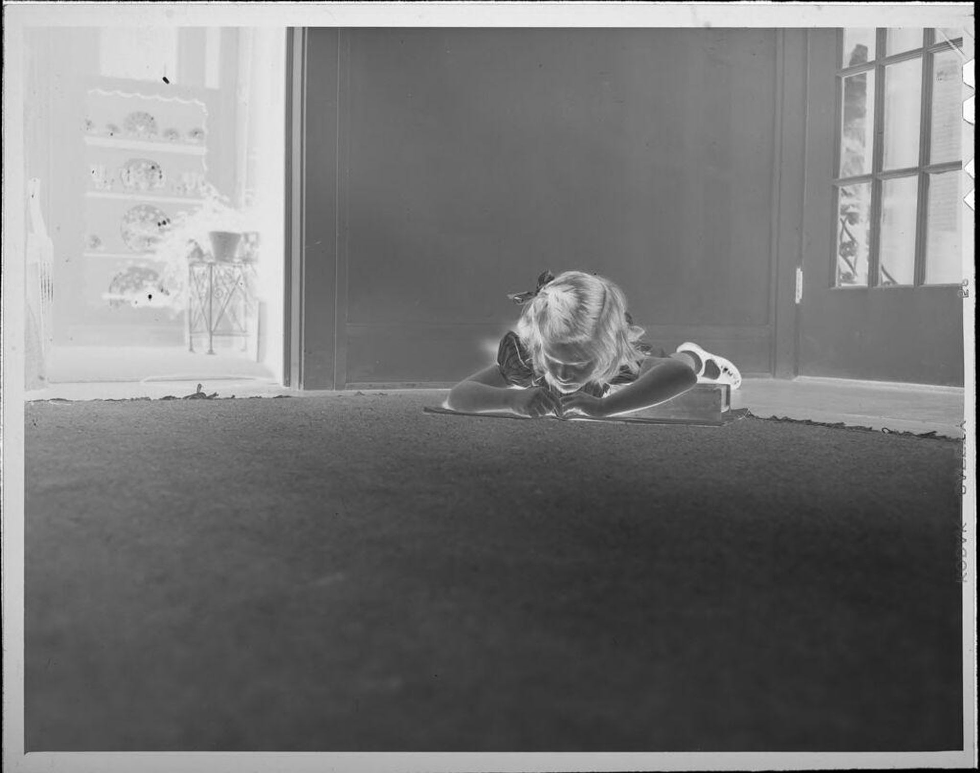 Untitled (girl lying on floor with book) by Lucian and Mary Brown