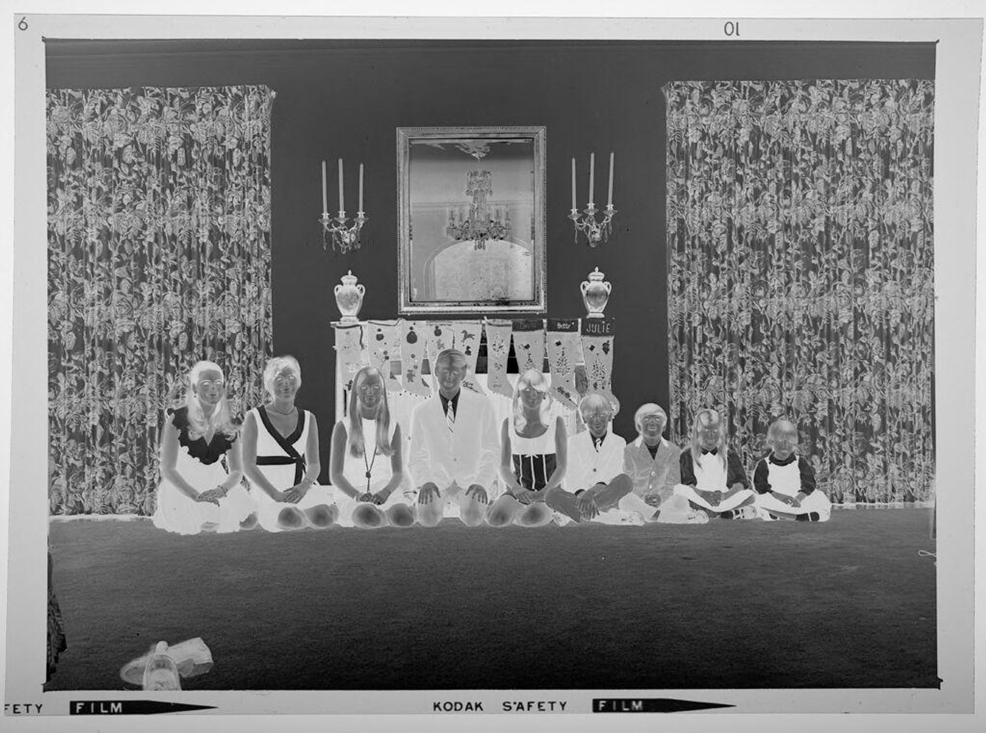 Untitled (nine children posed sitting in front of fireplace decorated for Christmas) by Martin Schweig