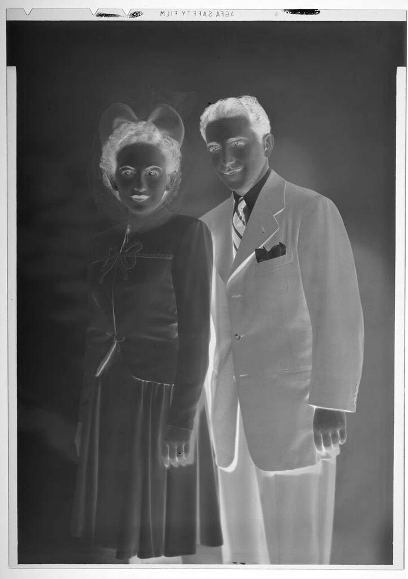 Untitled (studio portrait of couple with woman wearing bow shaped hat and man wearing striped tie) by Martin Schweig