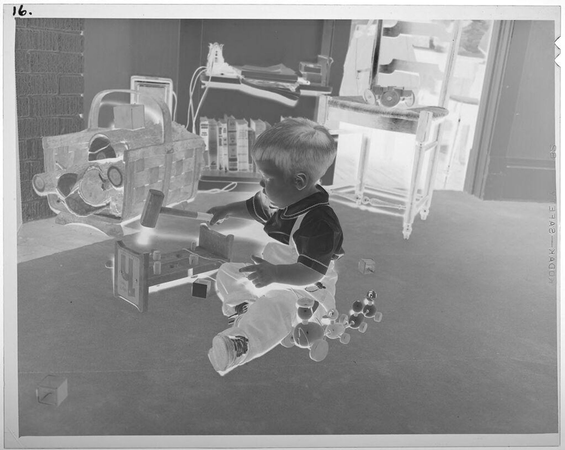 Untitled (boy on floor playing with wooden toys) by Lucian and Mary Brown