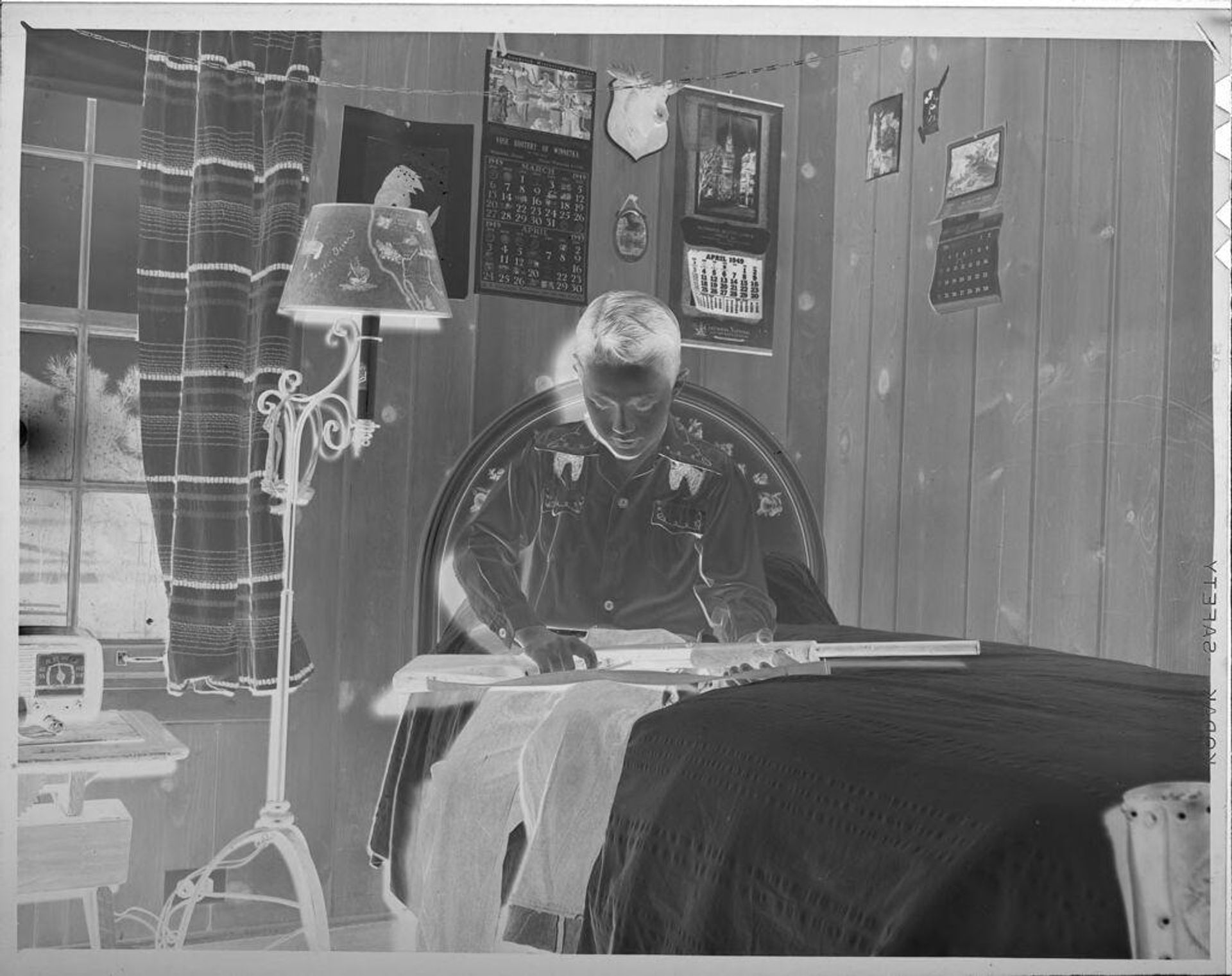 Untitled (boy holding gun on bed) by Lucian and Mary Brown