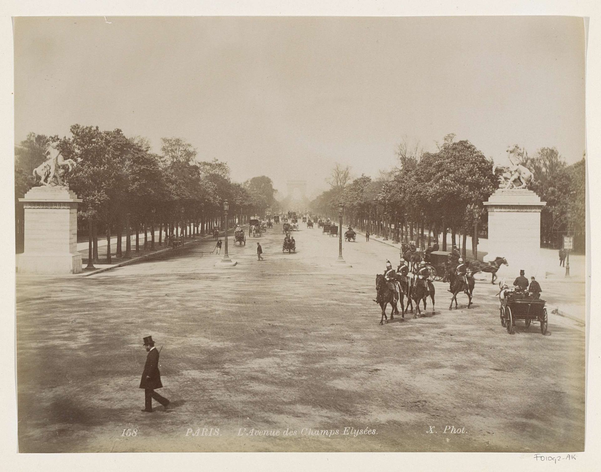 Voorbijgangers, paardenkoetsen en ruiters op de Avenue des Champs Elysées in Parijs by X phot.
