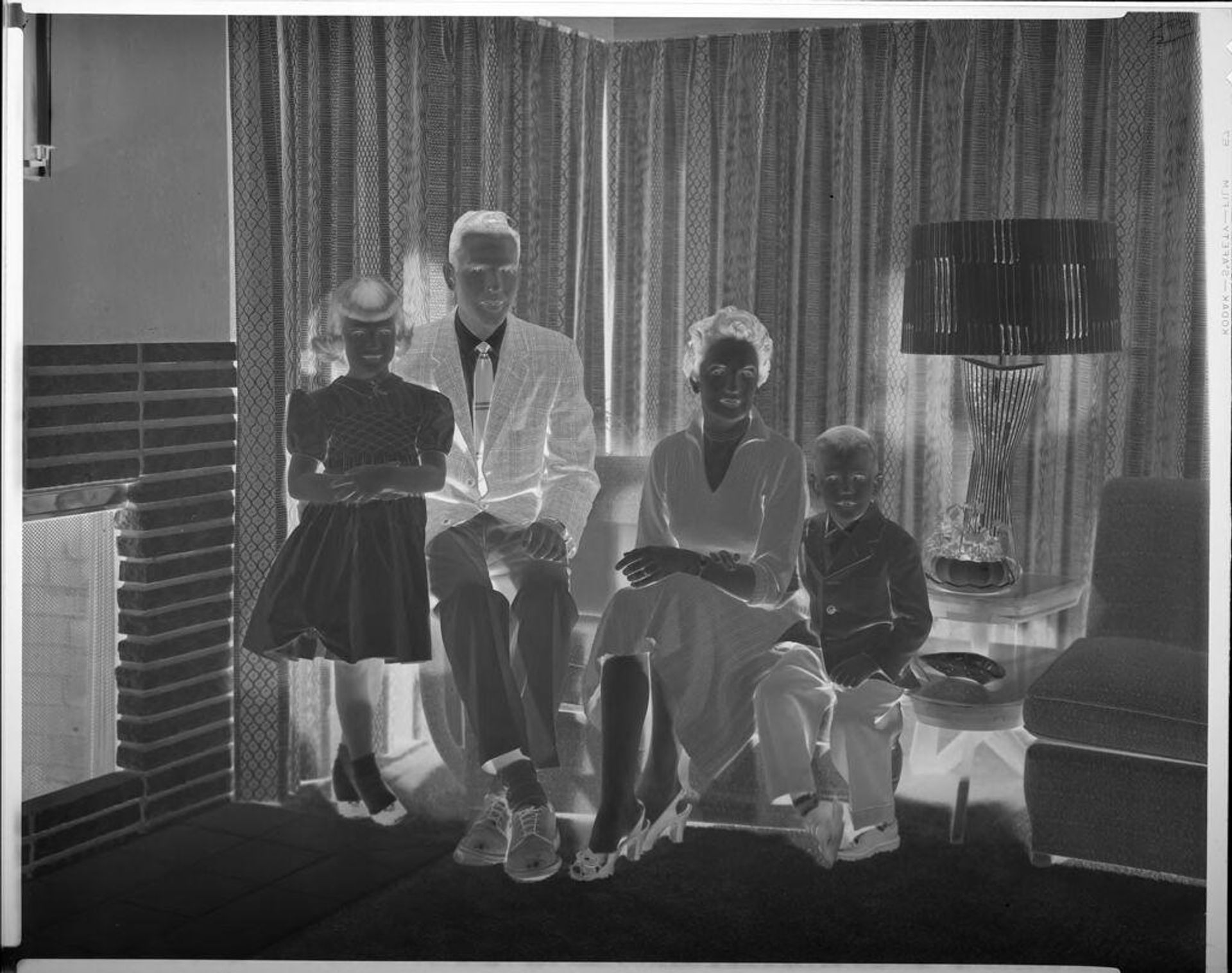 Untitled (family of four in living room) by Lainson Studios