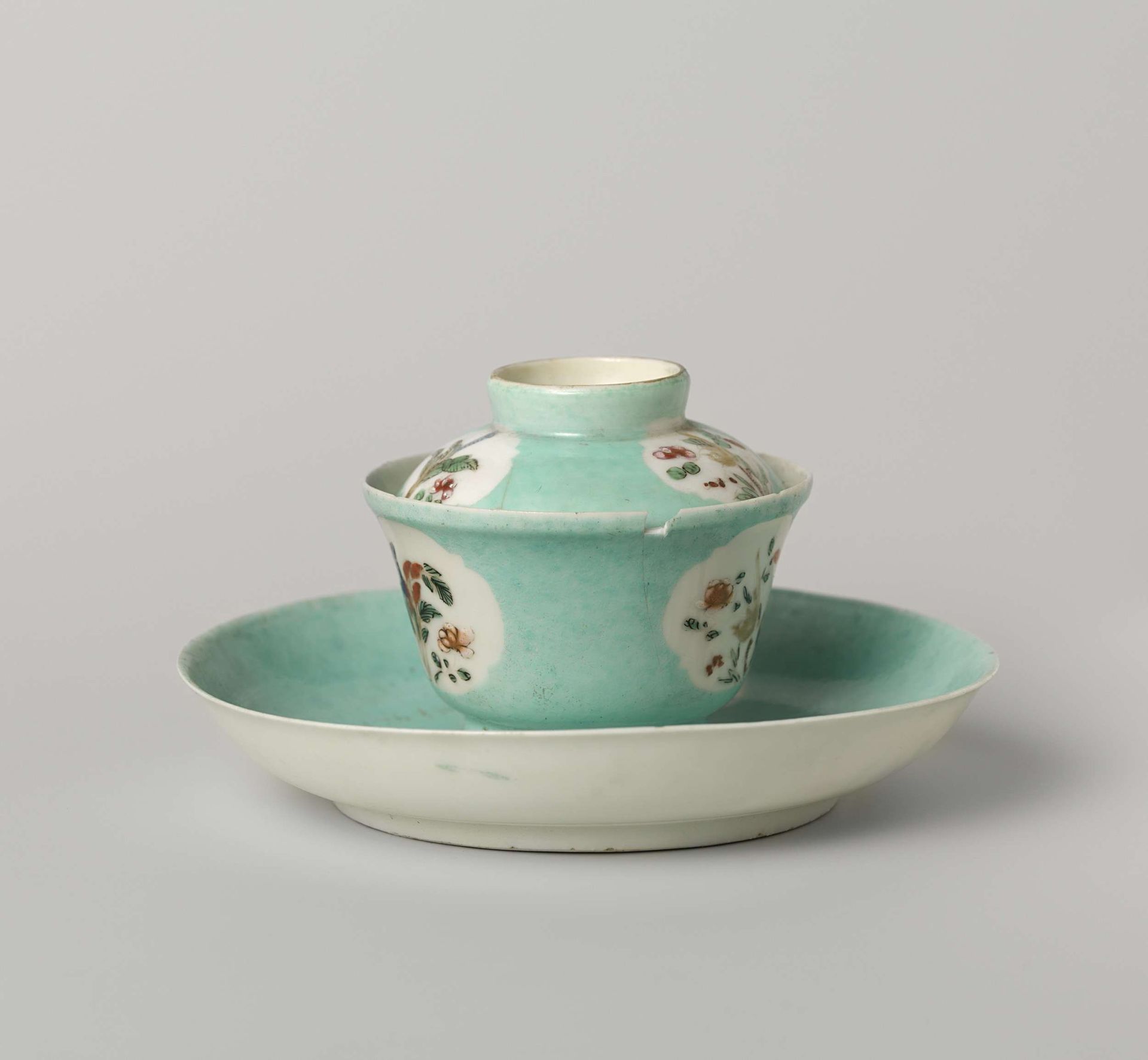 Bell-shaped covered cup and saucer with flowering plants in shaped panels by Anonymous