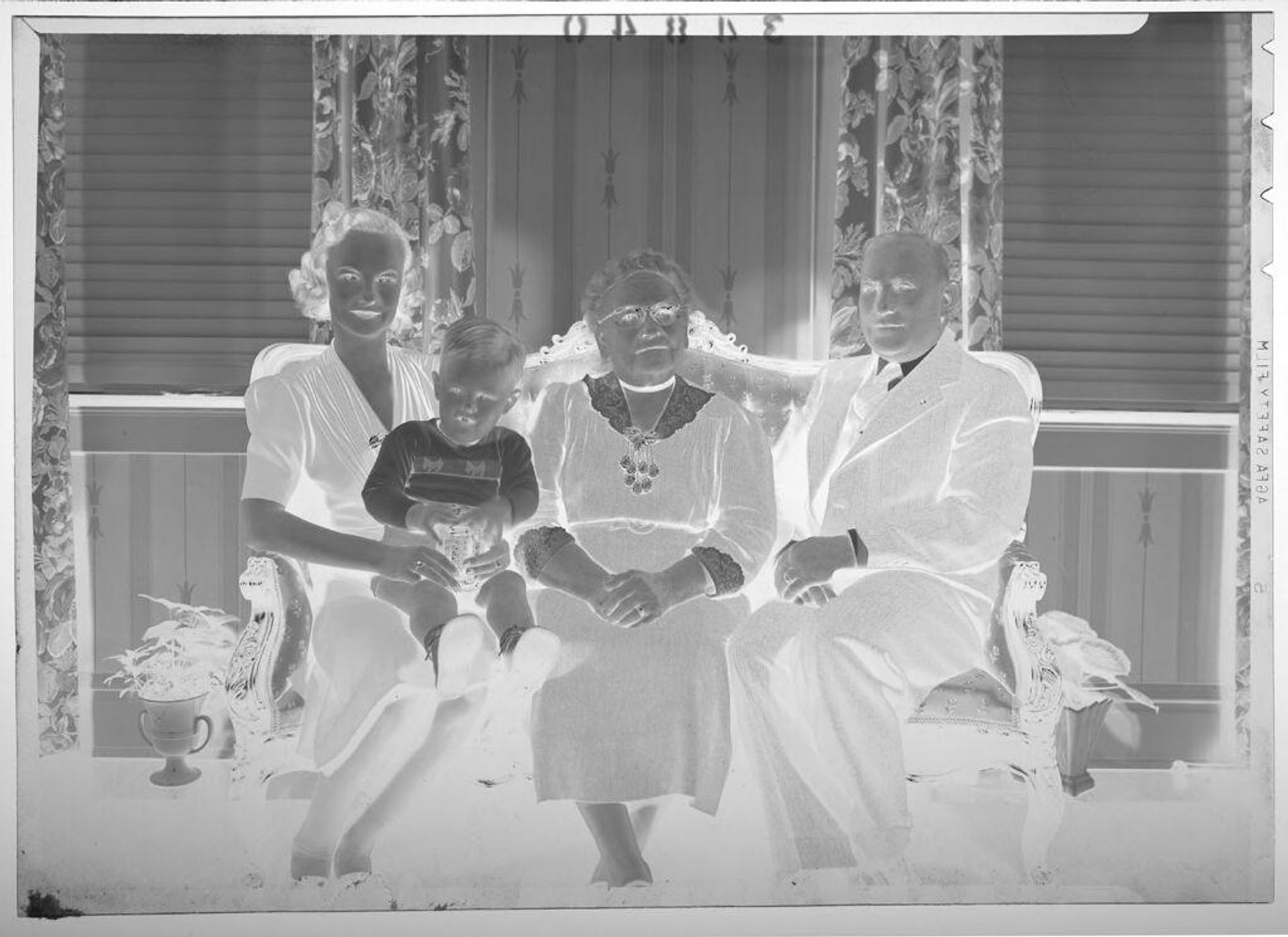 Untitled (older couple posed sitting on couch with younger woman and small boy) by Martin Schweig