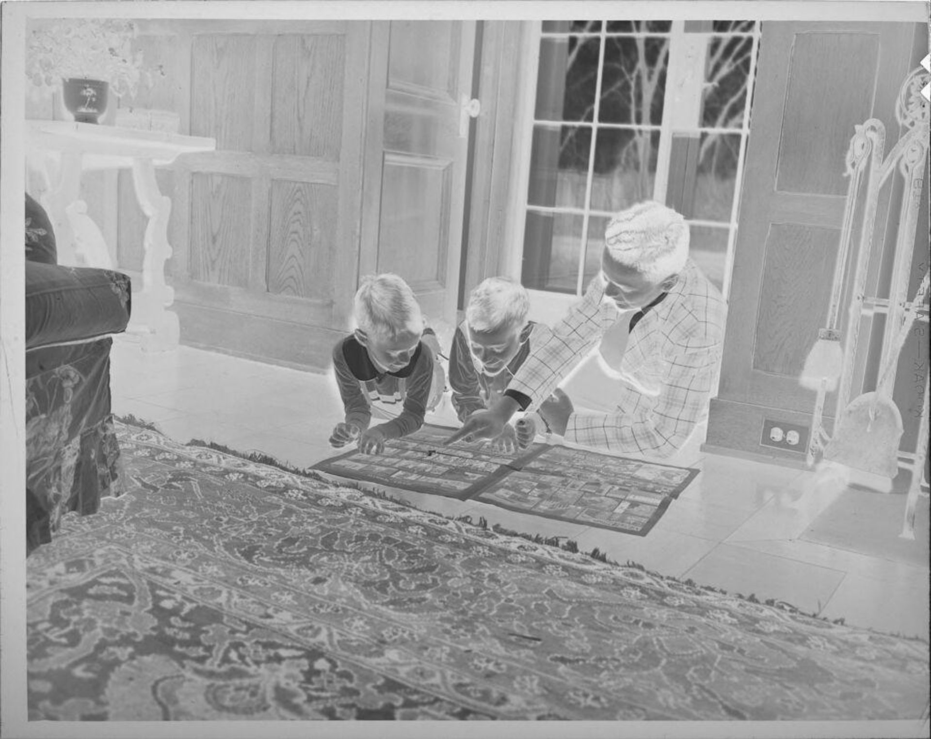 Untitled (boys reading comics on floor) by Lucian and Mary Brown