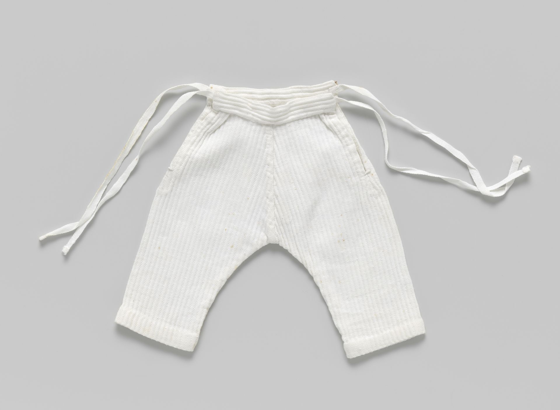 Broek van piqué, met lange pijpen en met banden by P. Titjen-Baas