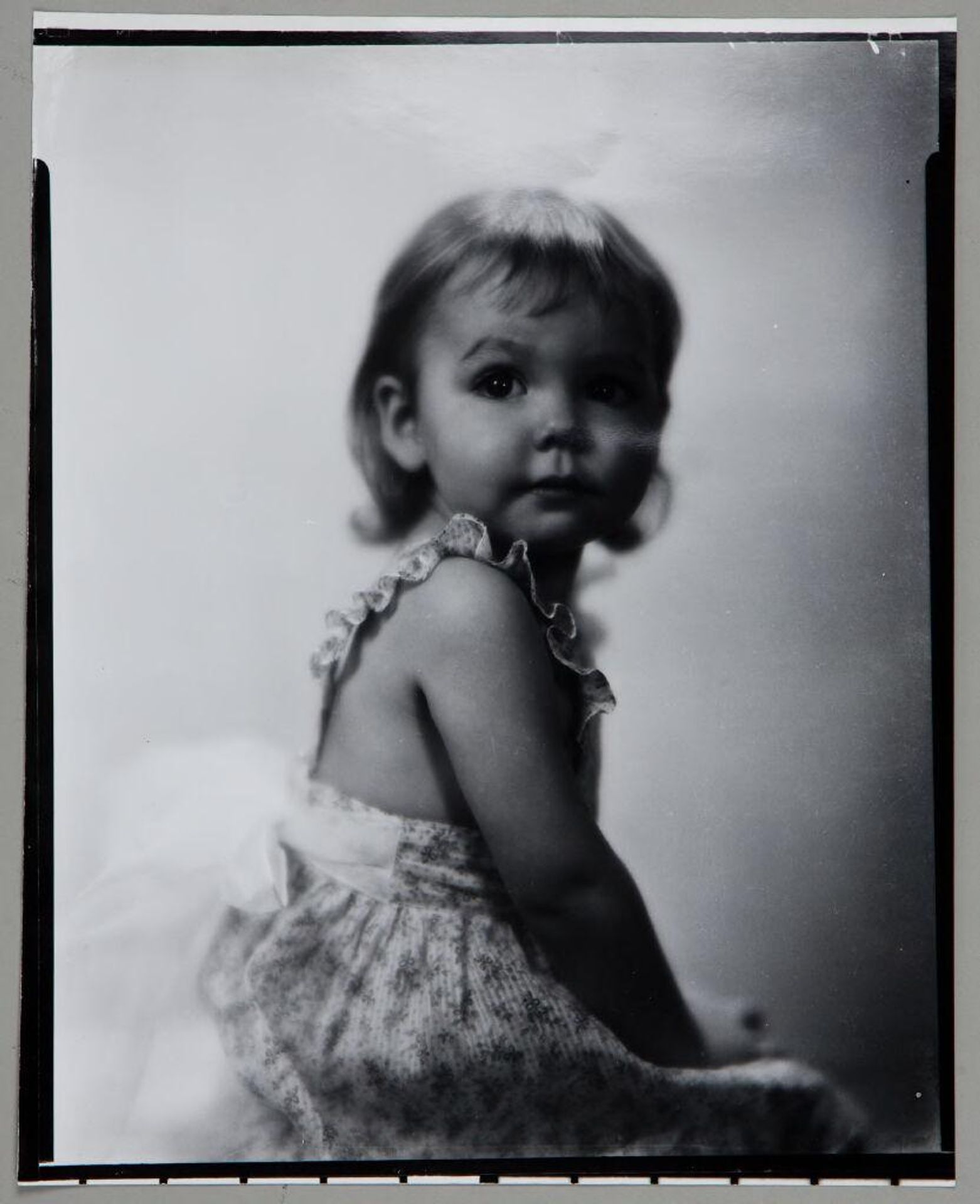 Untitled (little girl in sleeveless dress looking back over her shoulder) by Paul Gittings