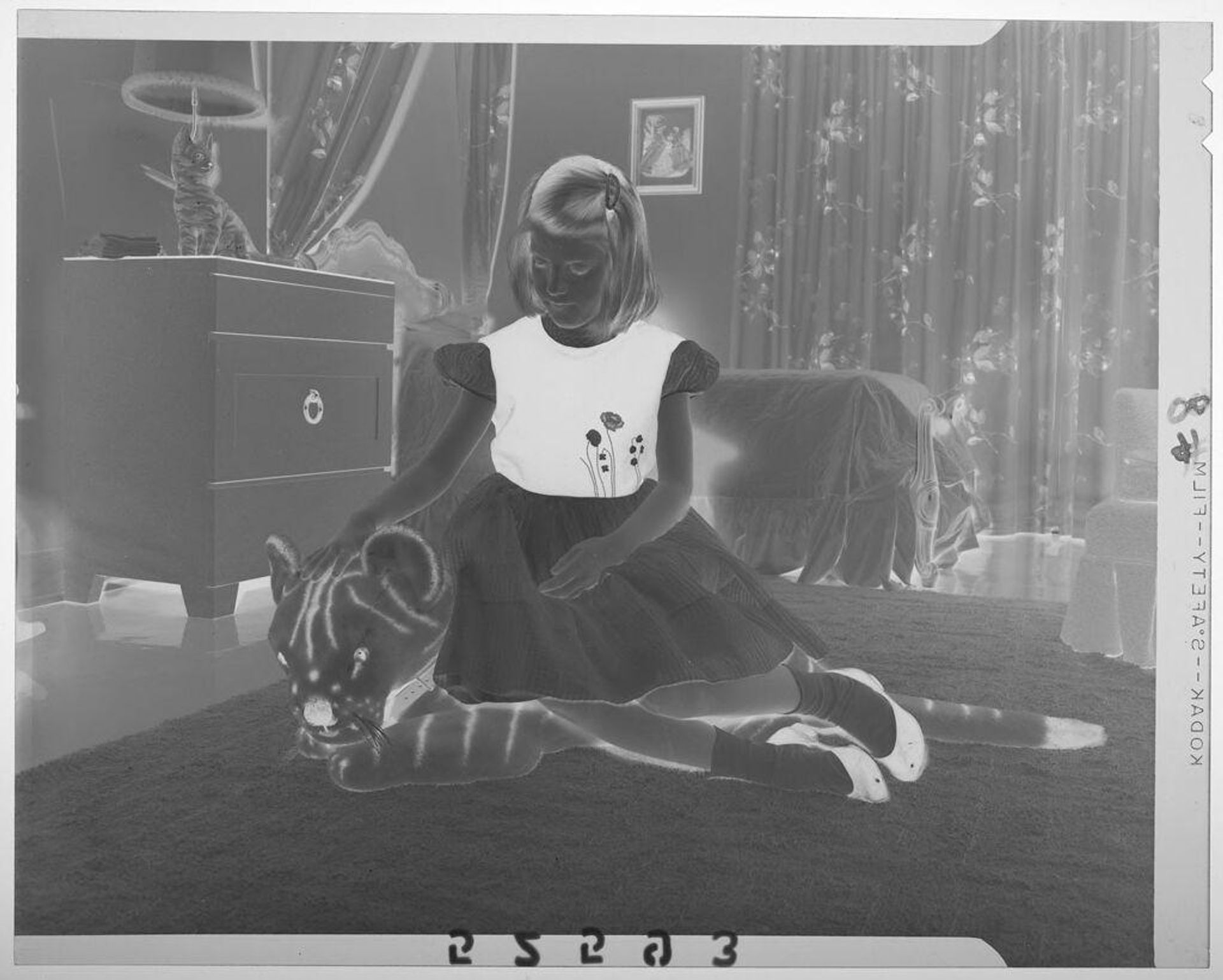 Untitled (young girl posed sitting on and petting stuffed tiger in bedroom) by Martin Schweig