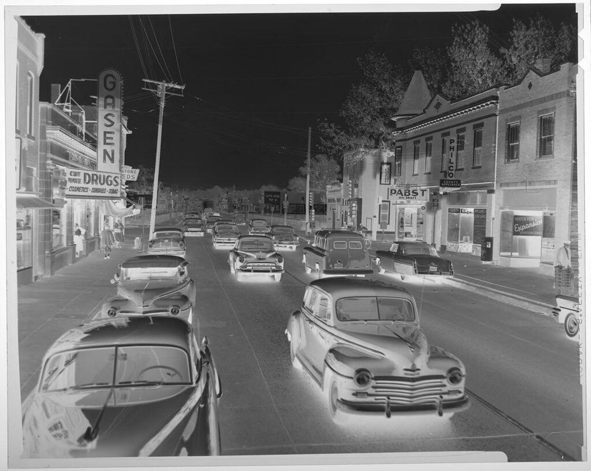 Untitled (cars on busy city street; drug store sign) by Jack Gould