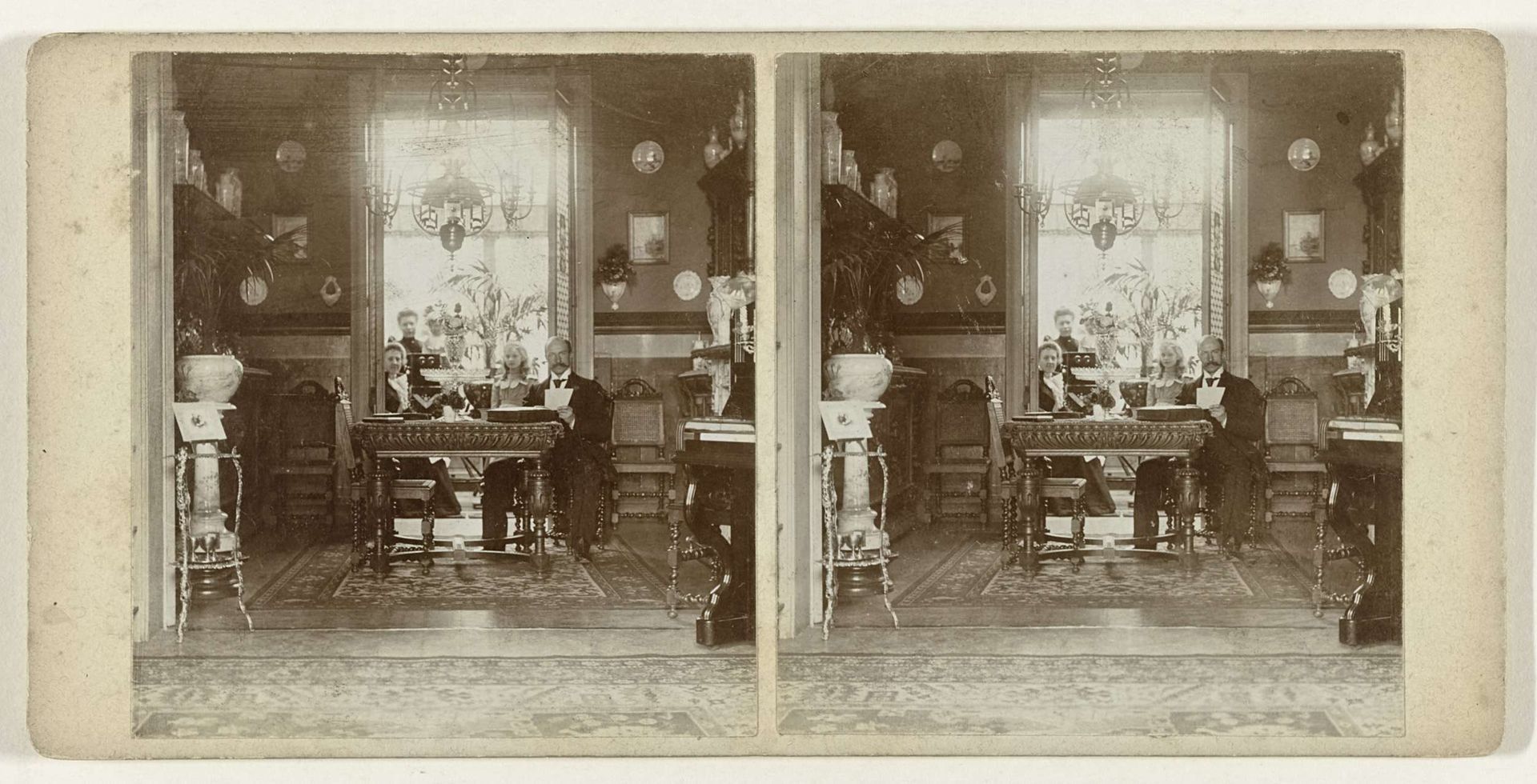 Interieur van de familie De Schamphelaere (Gent, België) met vier personen en een stereokijker by Oswald De Schamphelaere