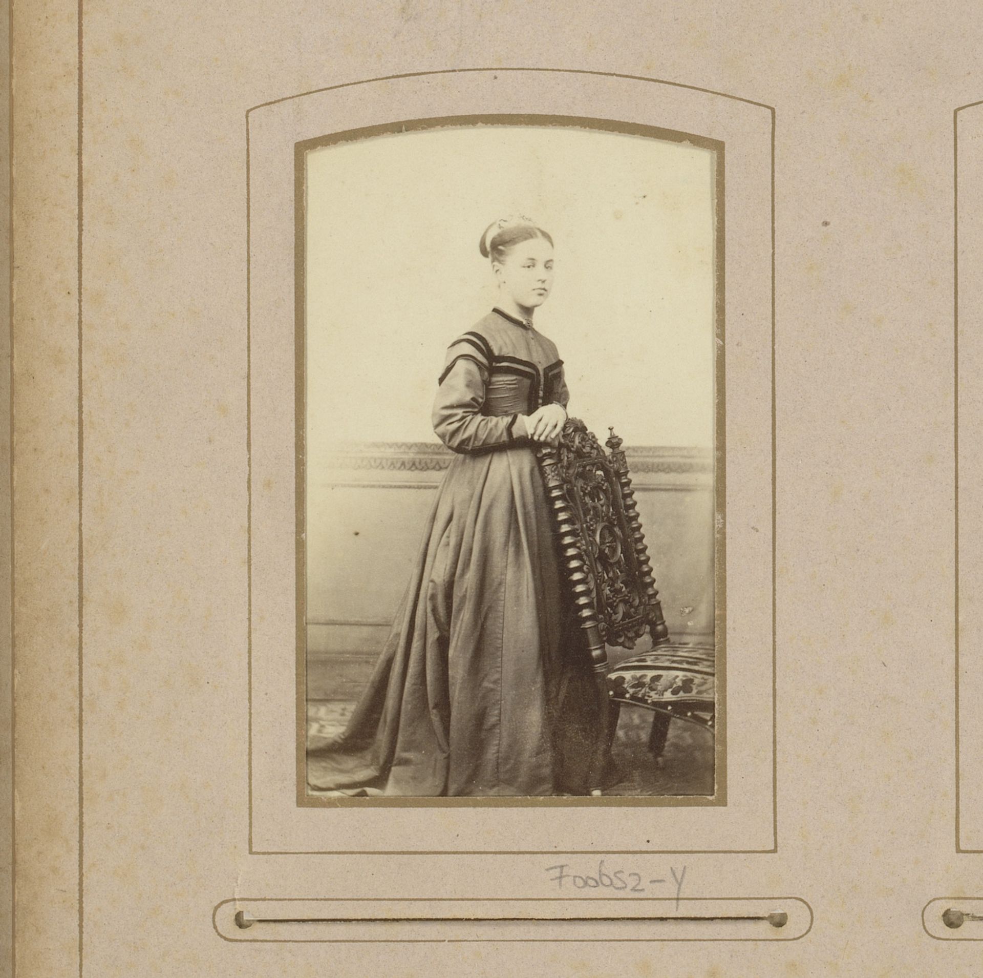 Portret van een jonge vrouw, staand bij een stoel by Carte de Visite Studio