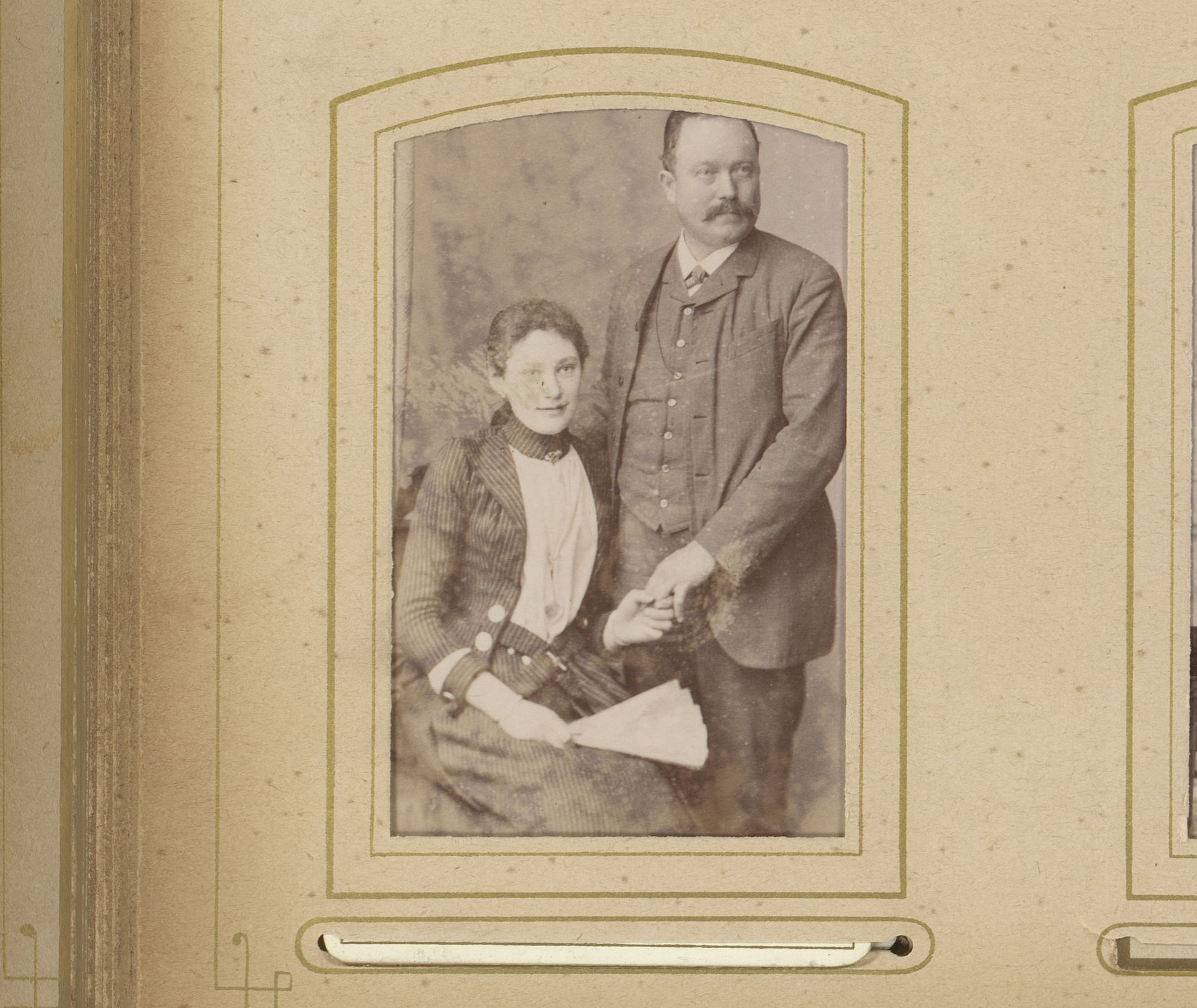 Portret van een zittende vrouw met waaier in de hand en een staande man by A. Basler