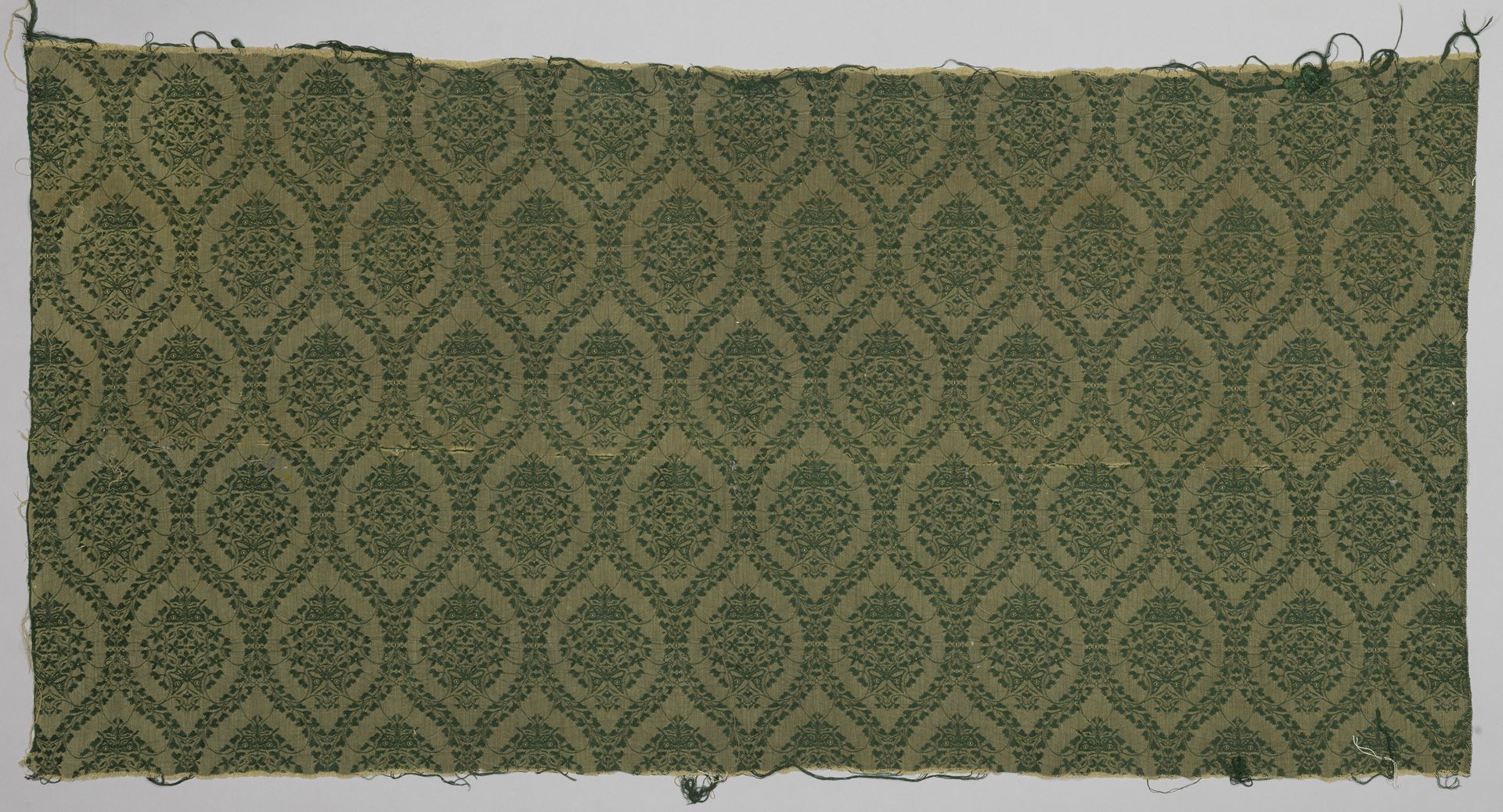 Bespanningsstof, jacquardweefsel met patroon van spitsovale velden met bladranken, donkergroene inslag op zachtgele ketting by Theo Nieuwenhuis