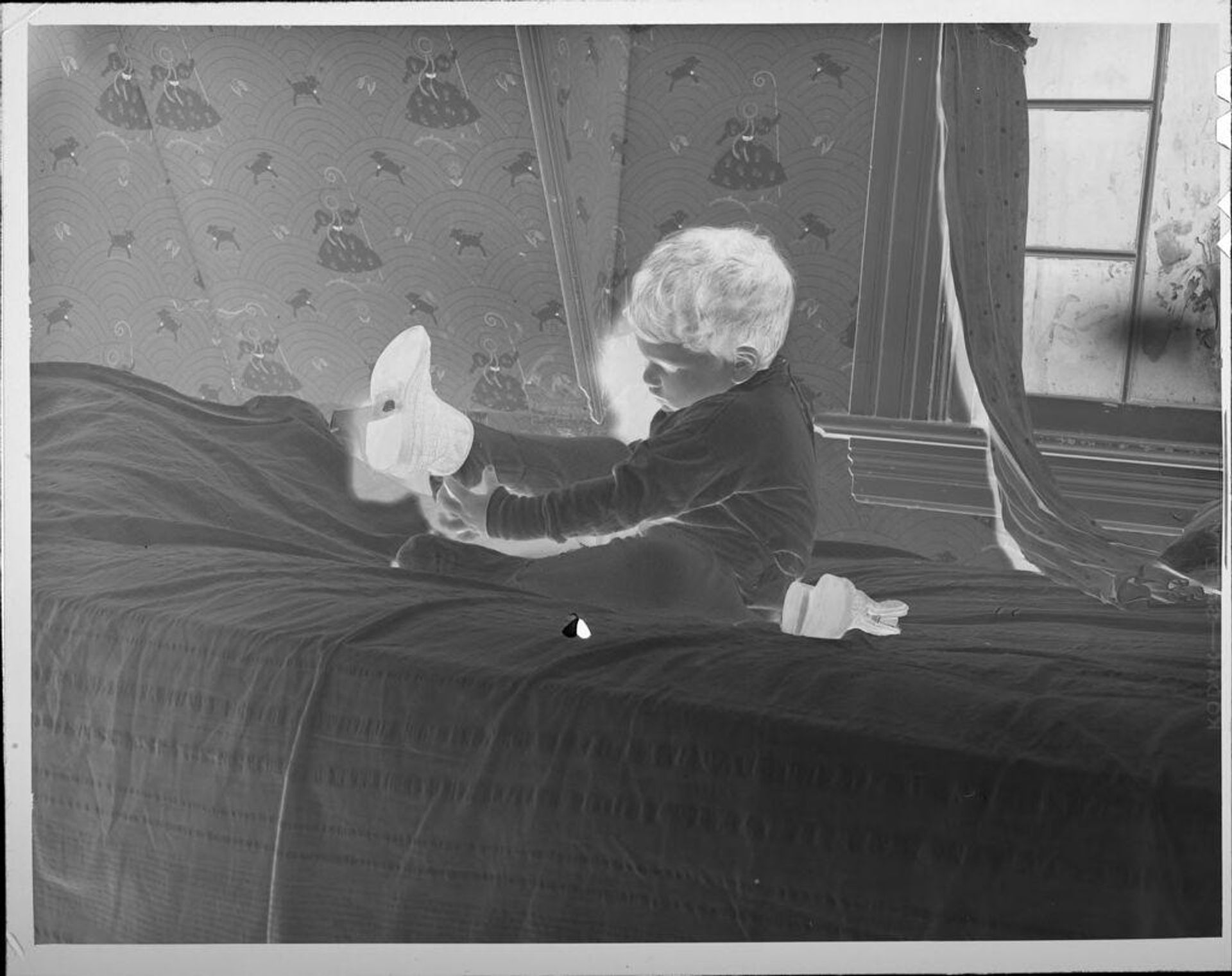 Untitled (boy on bed putting on shoes) by Lucian and Mary Brown