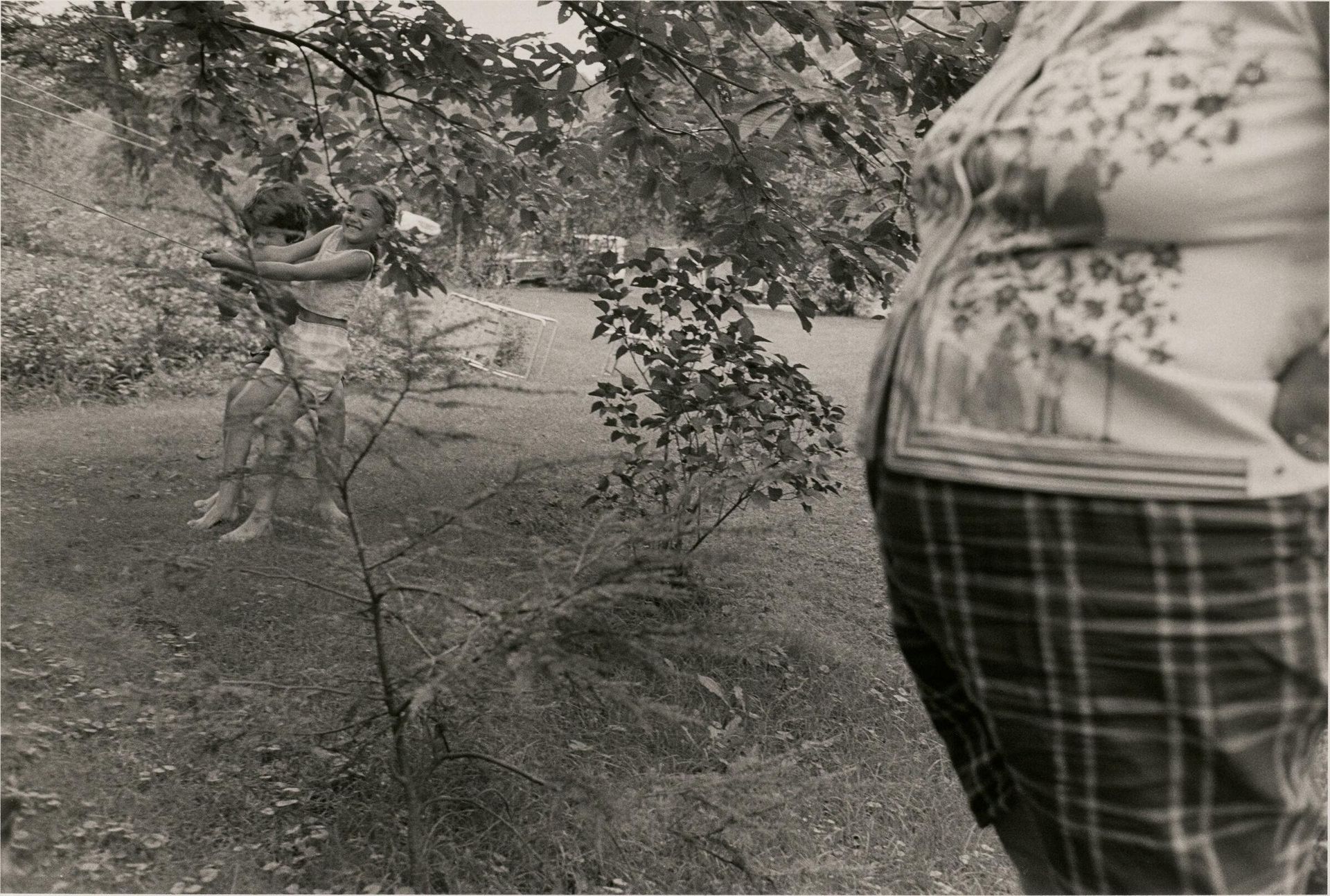 Sabatineâs, PA (Womanâs belly and two kids on tree swing) by Larry Fink