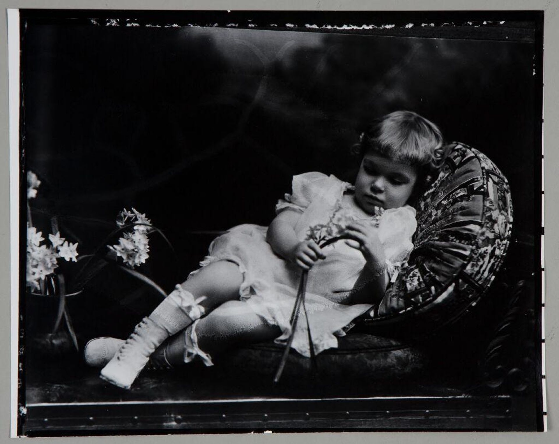 Untitled (child with narcissus flowers reclined on cushion) by Paul Gittings