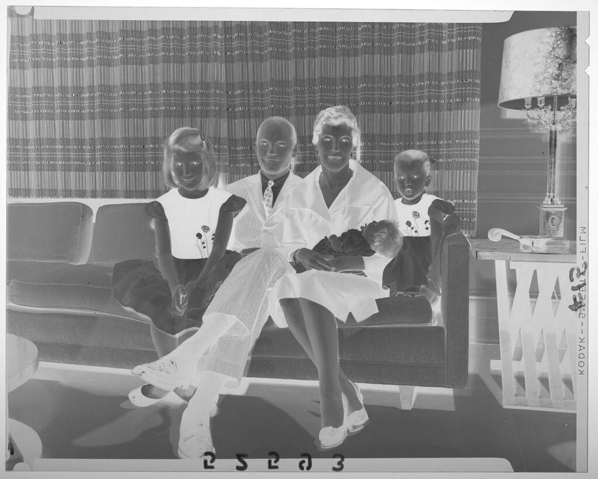 Untitled (family with two girls and baby posed sitting on living room couch) by Martin Schweig
