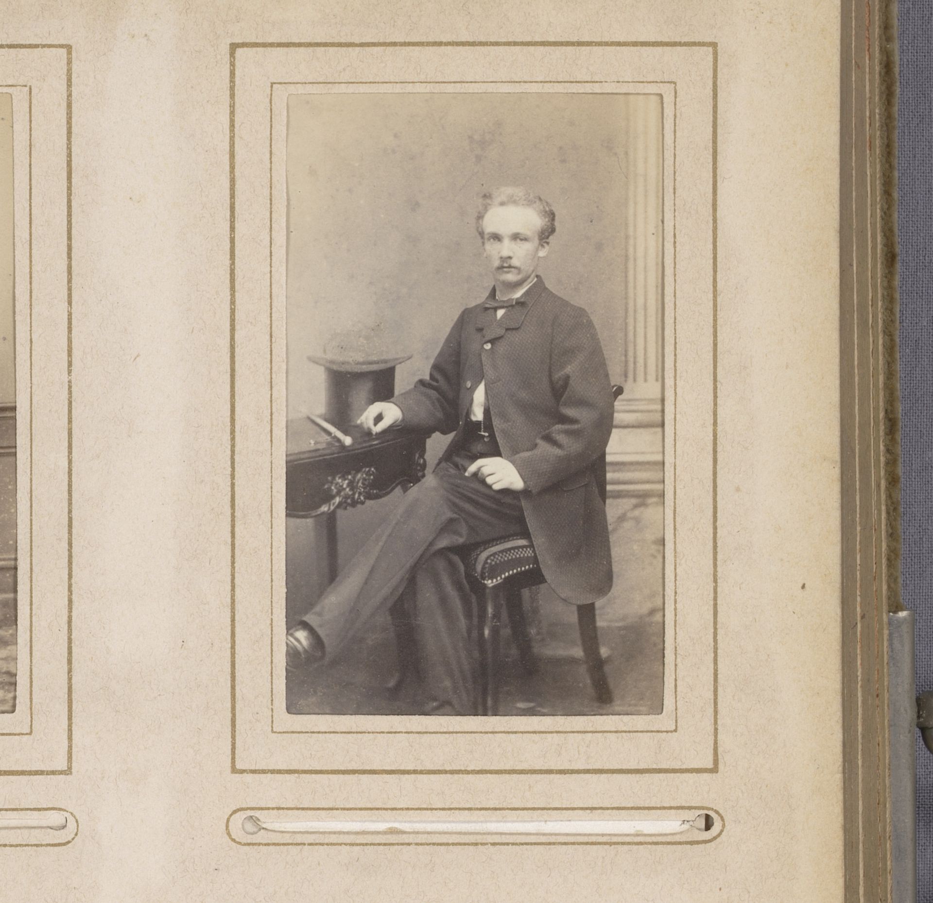 Portret van een man, zittend aan een tafel met een hoge hoed by Eduard Fuchs