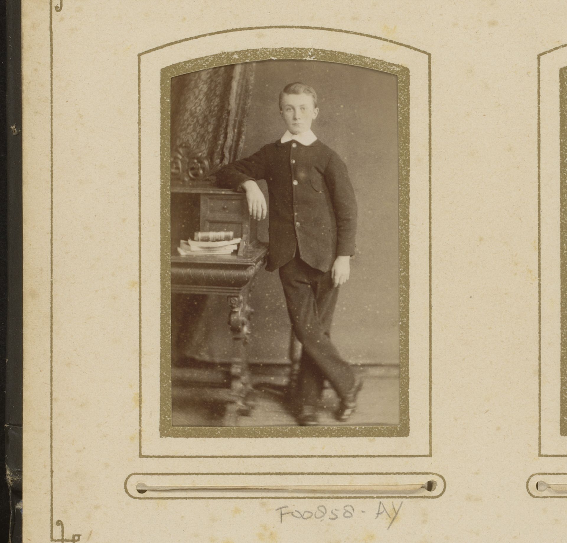 Portret van een jongen, leunend op een bureau met boeken by Albert A. Kleintjes