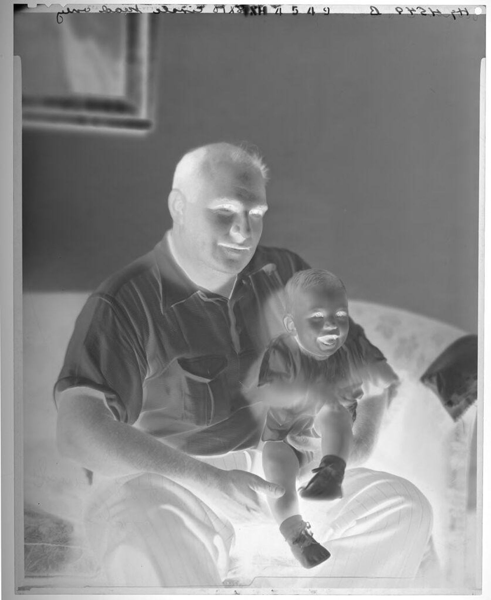 Untitled (portrait of man holding baby on knee) by Paul Gittings