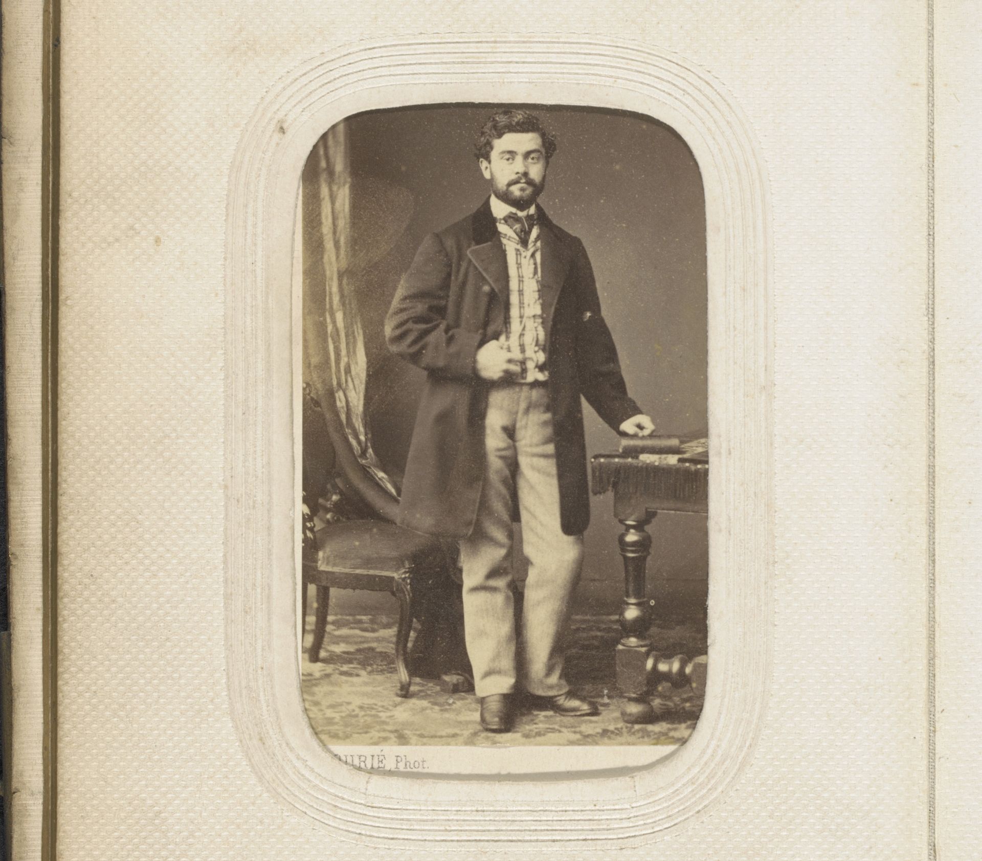 Portret van een staande man bij tafel met een boek by Fourie