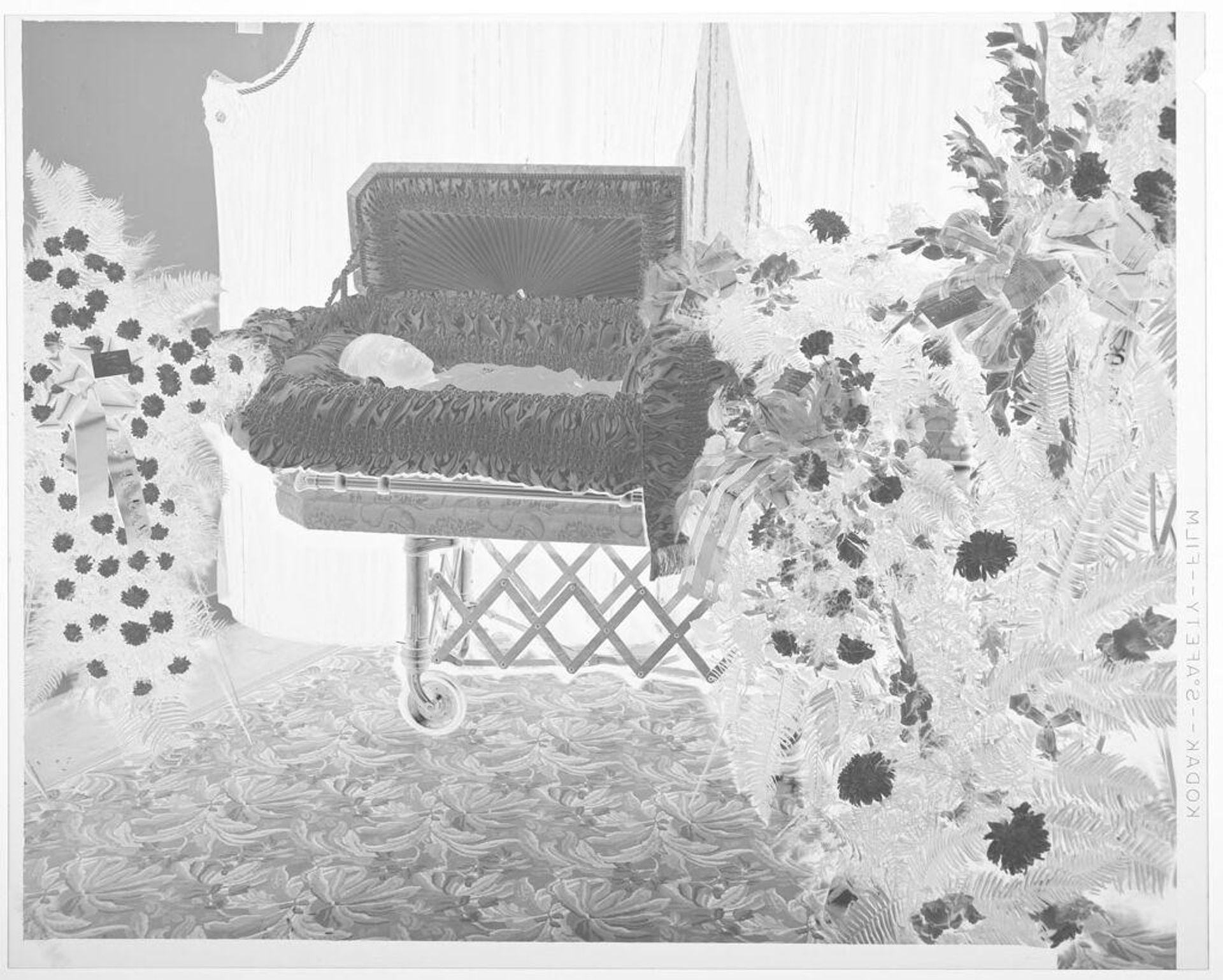 Untitled (man lying in open casket) by Hamblin Studio