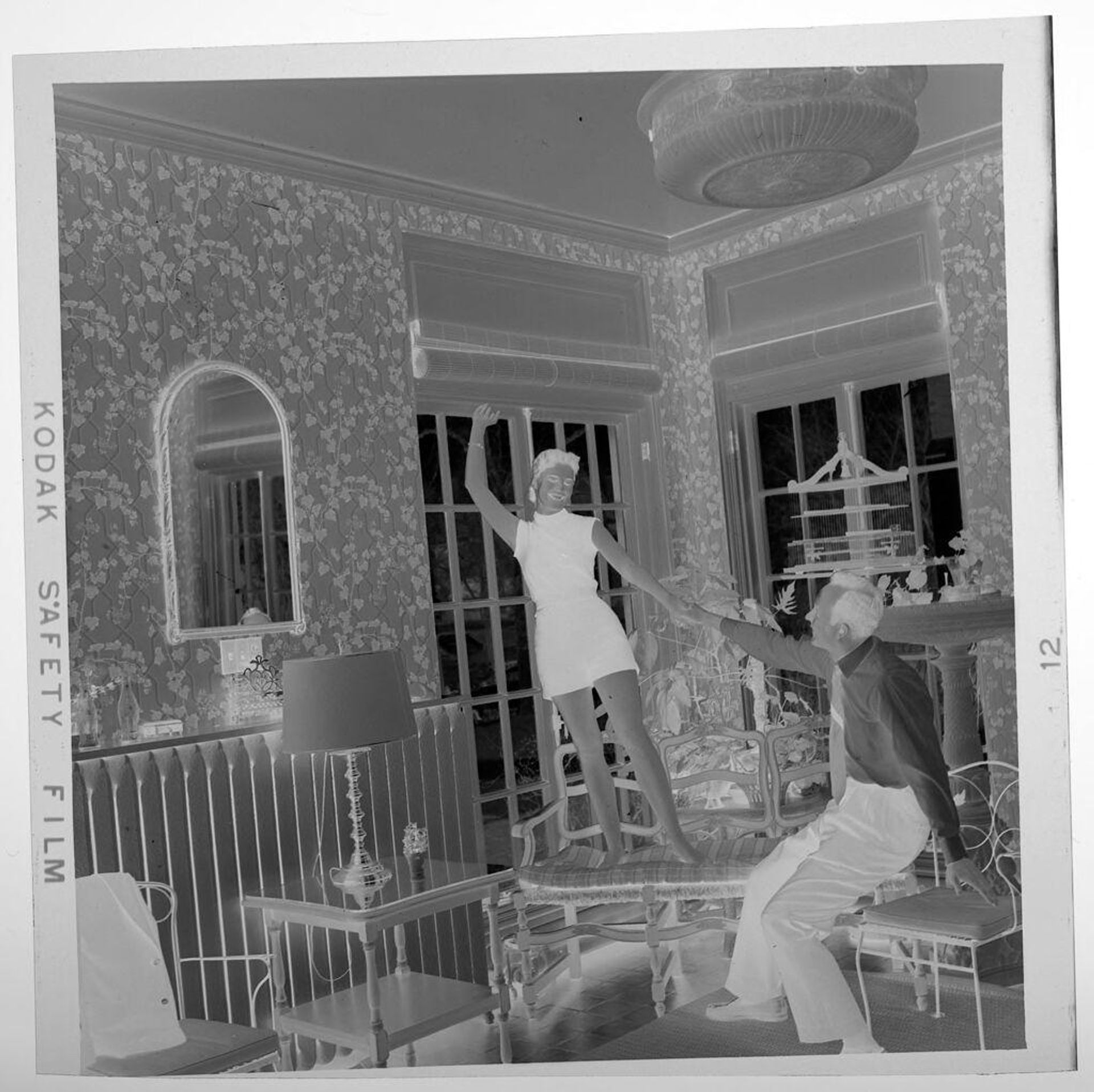 Untitled (seated man and standing women on bench with arms raised) by Jack Gould