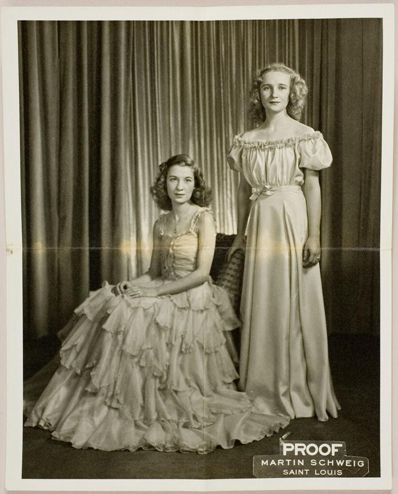 Untitled (studio portrait of two young women in formal dresses with one girl sitting) by Martin Schweig