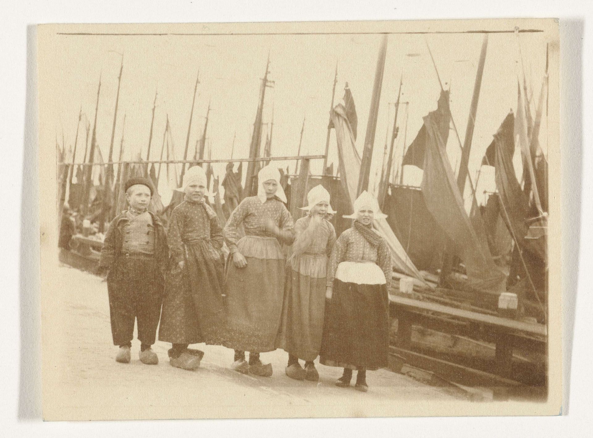 Groepsportret van vijf onbekende kinderen in klederdracht in de haven van Volendam by G. Hidderley
