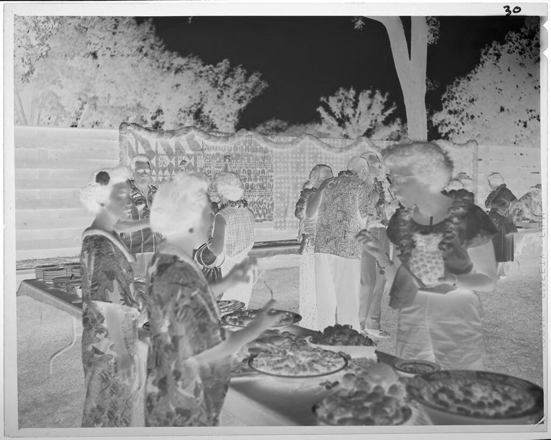 Untitled (people serving and eating food at Luau) by Lucian and Mary Brown
