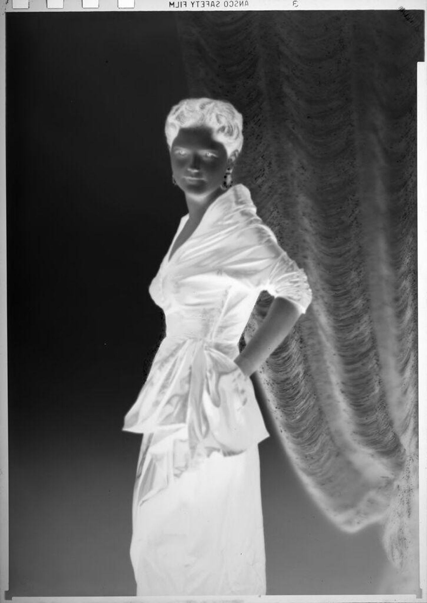 Untitled (Eugenie Stoll in formal gown in front of curtain) by C. Bennette Moore